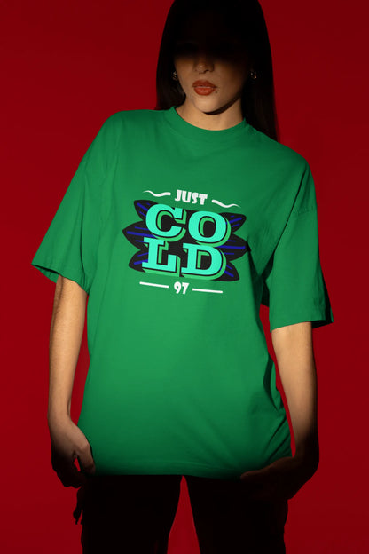 Second front view of a female model wearing an forest green oversized t-shirt with the text "Just Cold" printed on it.