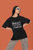 First front view of a female model wearing a black oversized t-shirt with the text 