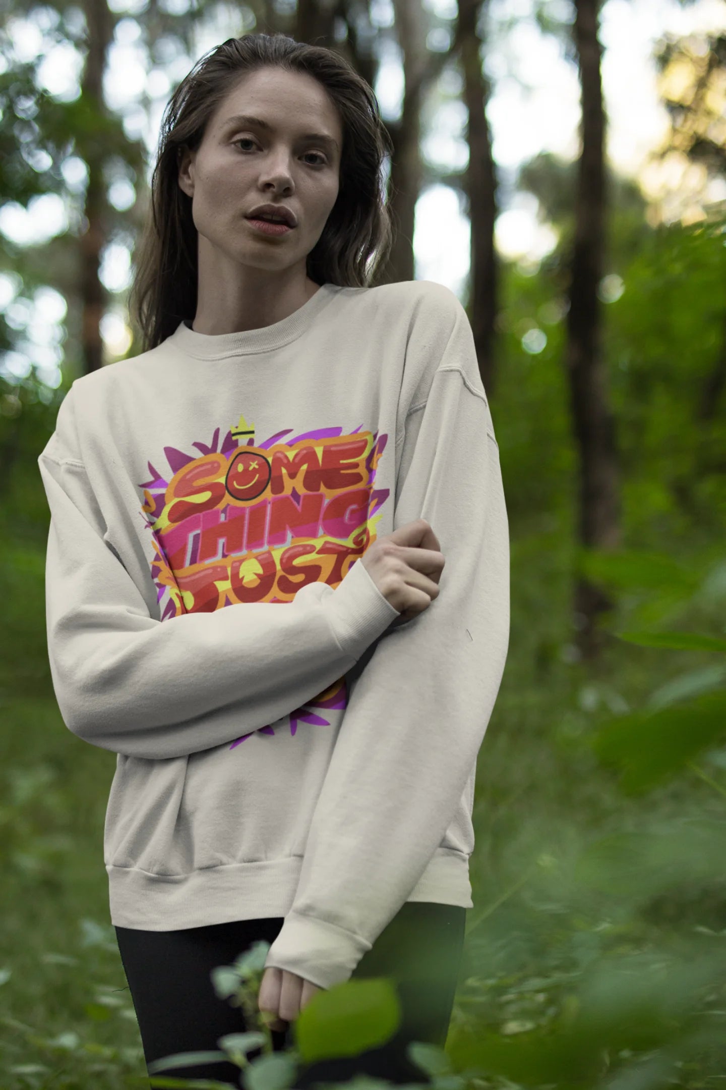 Second front view of a female model wearing an cream sweatshirt featuring the designs inspired from Coldplay's "Something Just Like This" music video.