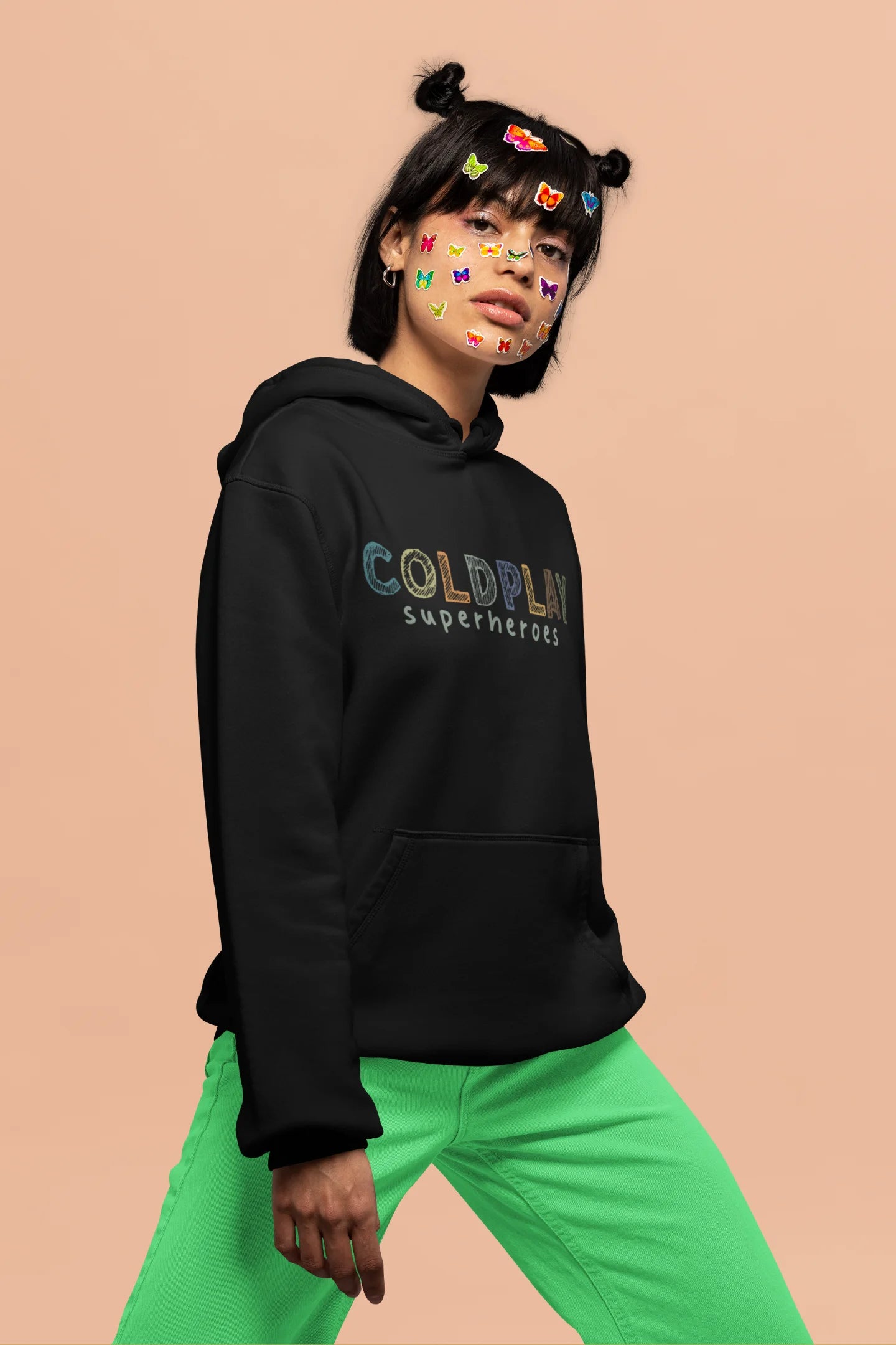 2nd front view of a female model wearing an black hoodie with a design inspired by the "Something Just Like This" music video, featuring the word "Superheroes".