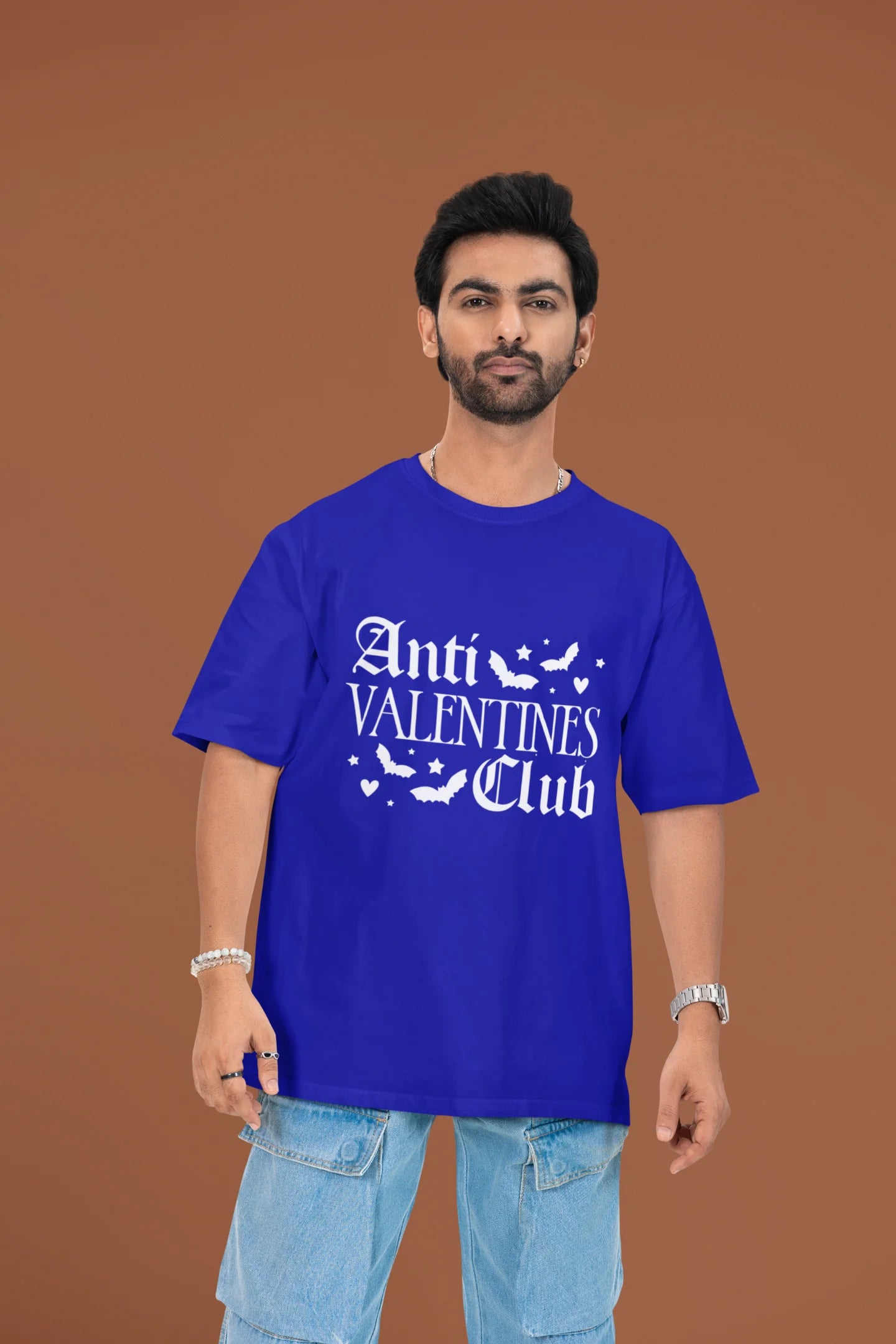 3rd front view of a male model wearing a royal blue oversized t-shirt with the text "Anti-Valentine's Club" printed on it.