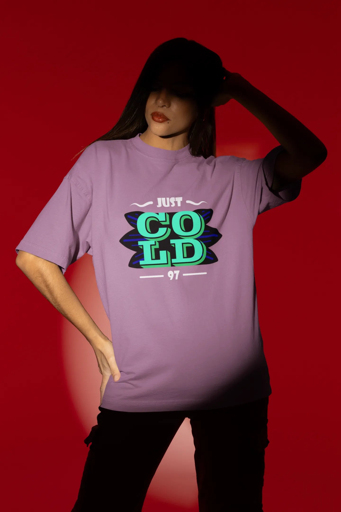 Third front view of a female model wearing an dirty purple oversized t-shirt with the text "Just Cold" printed on it.