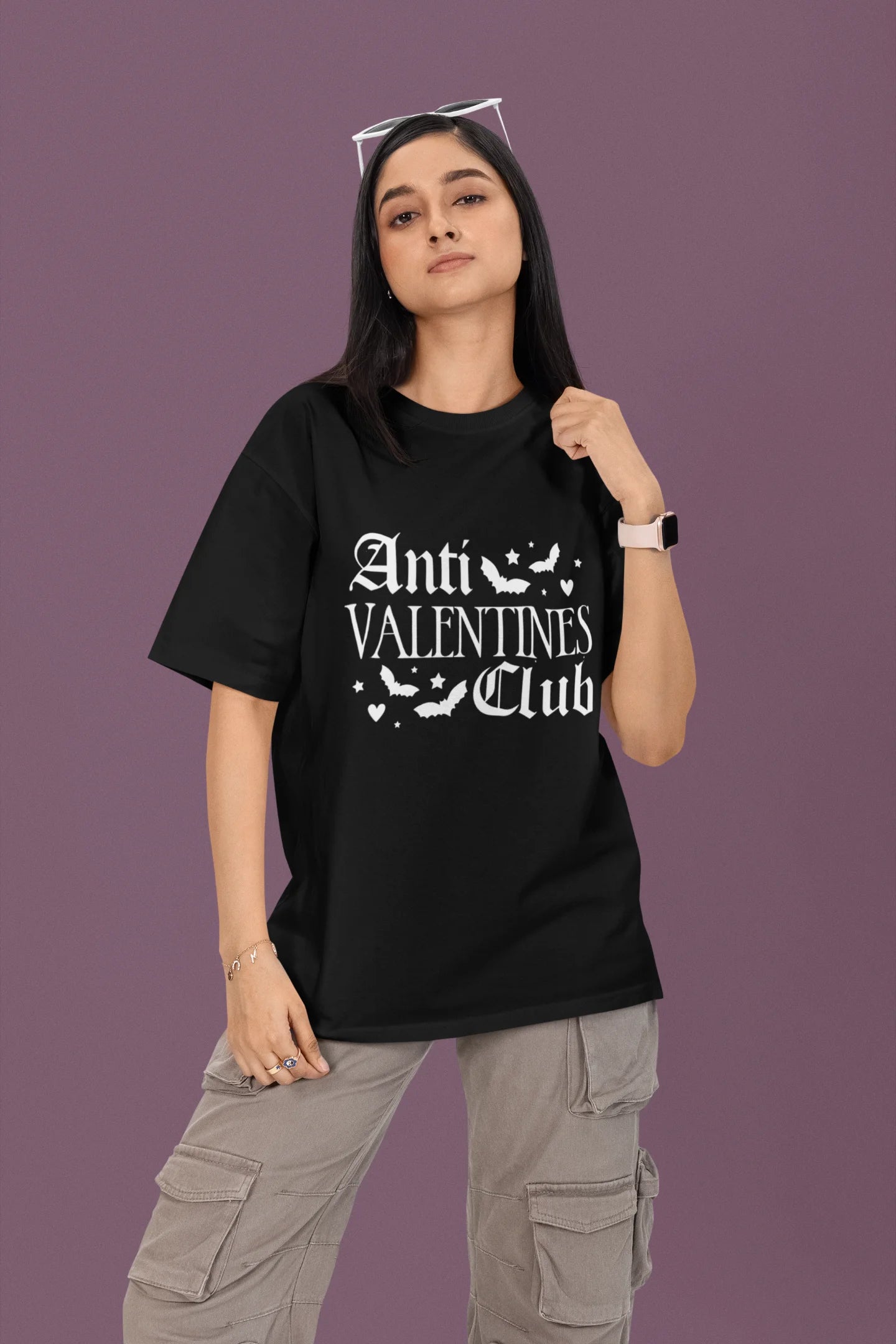 2nd view of a female model wearing a black oversized t-shirt with the text "Anti-Valentine's Club" printed on it.