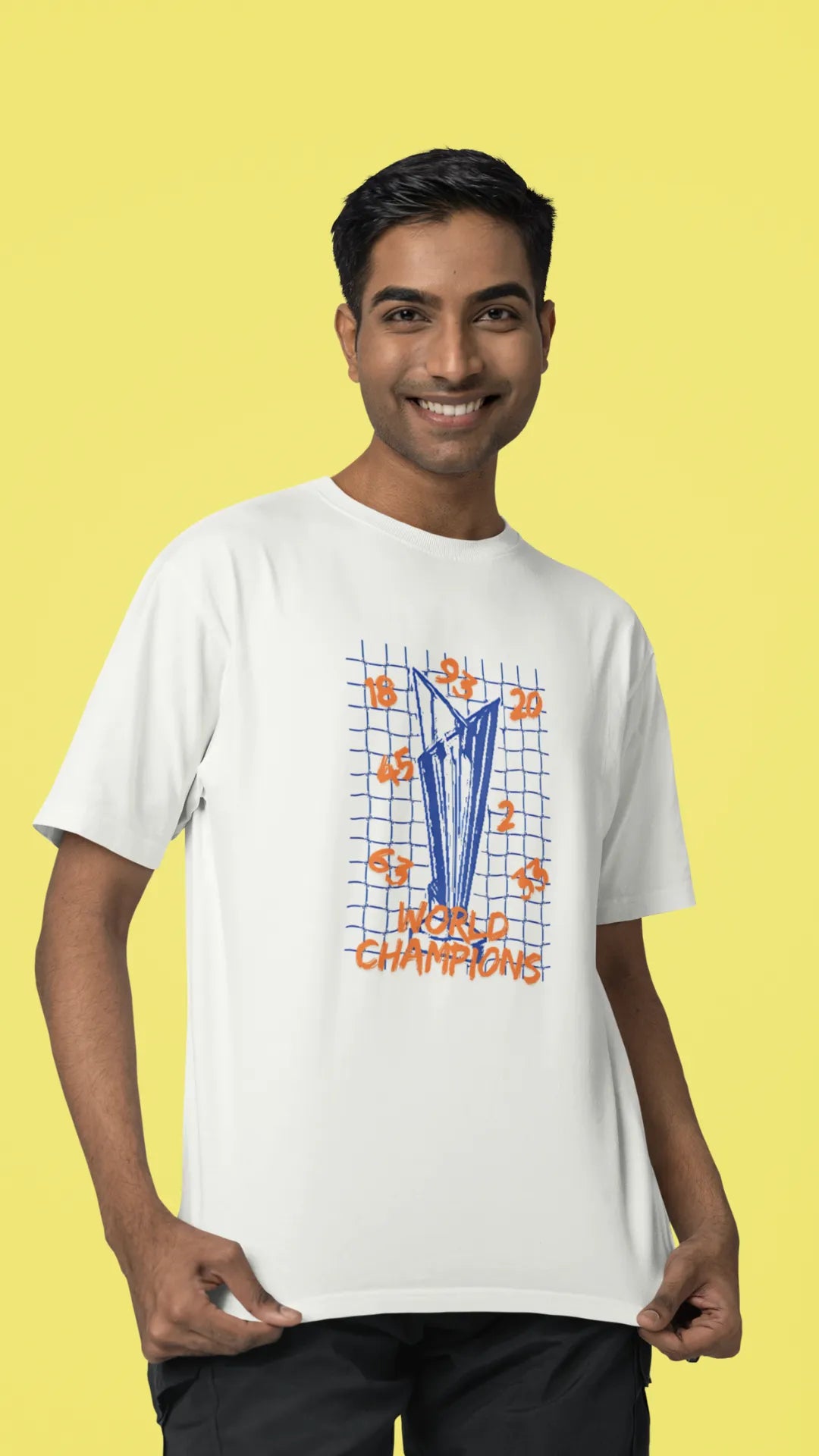 Second front image of male model wearing an off-white oversized t-shirt featuring the World Cup 2024 trophy with the text "World Champions" underneath. Ideal for Indian cricket fans celebrating their team's victory.