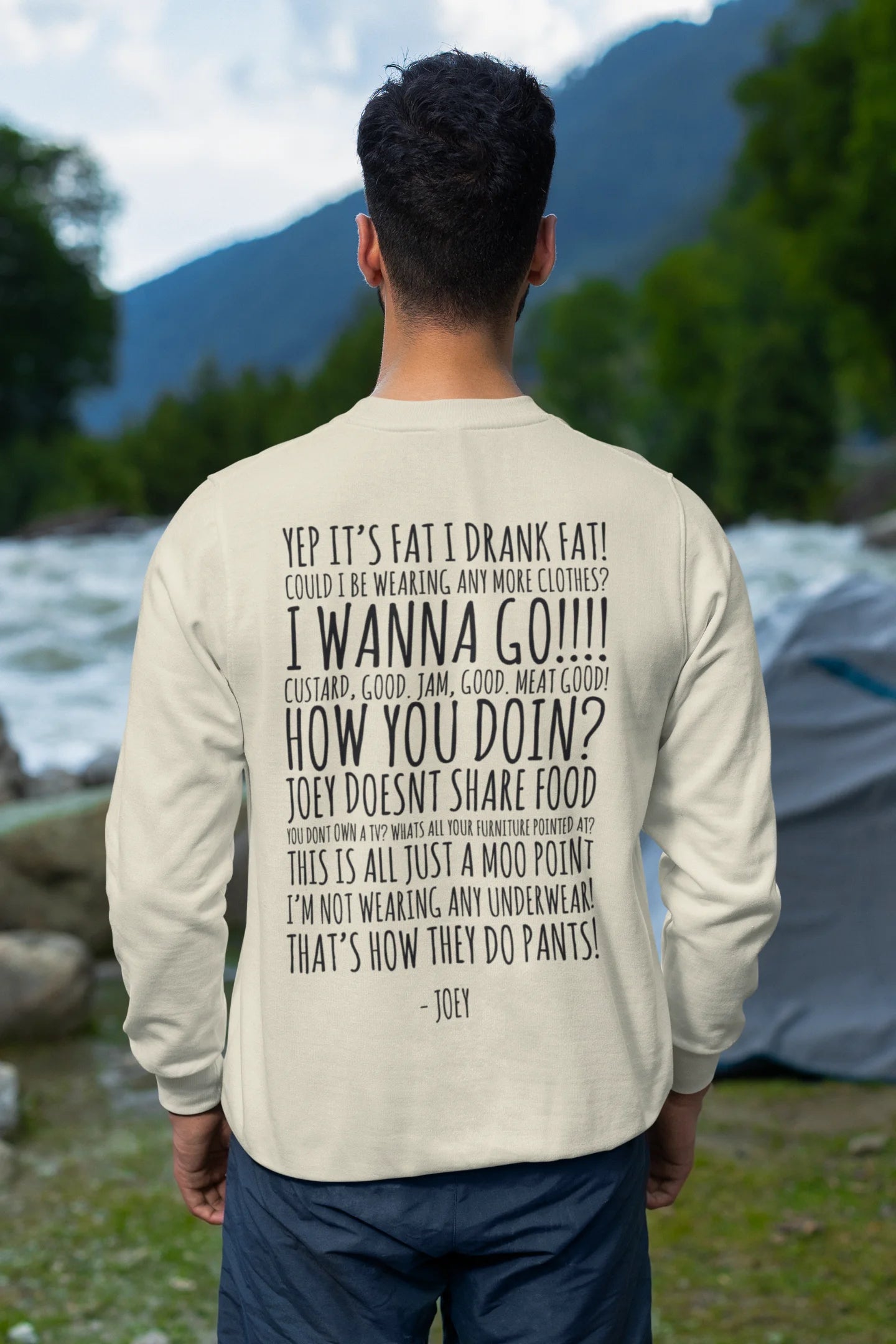 Back view of male model wearing a cream F.R.I.E.N.D.S. sweatshirt featuring a design inspired by Joey Tribbiani's funny quotes and signature charm.