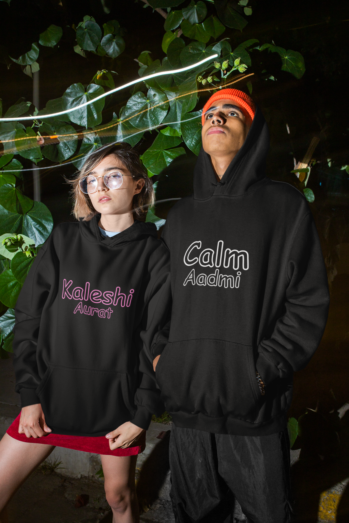  A cool couple wearing matching hoodies, one with "Calm one" and the other with "Chaotic one" printed on them in Hindi.