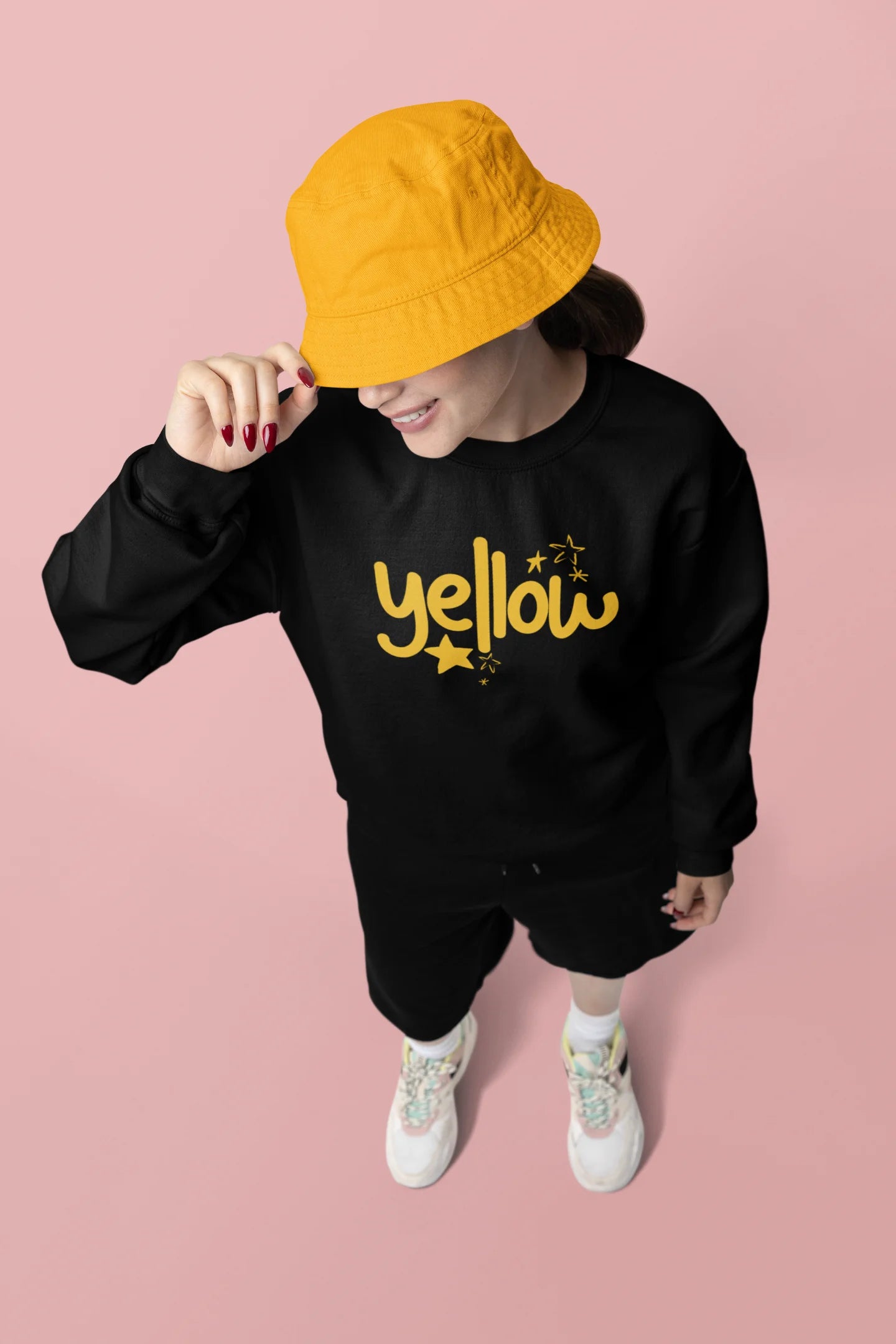 Third front view of a female model wearing a black sweatshirt with the "Yellow" album artwork by Coldplay.