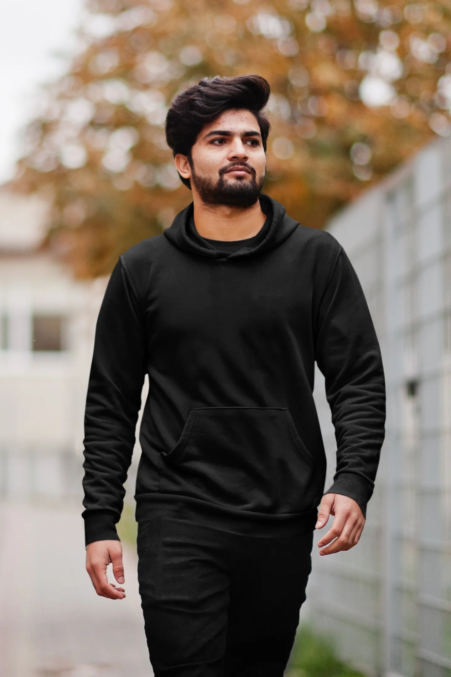 Second front view of a male model wearing a black hoodie featuring a Range Rover Defender design, exuding power and ruggedness.