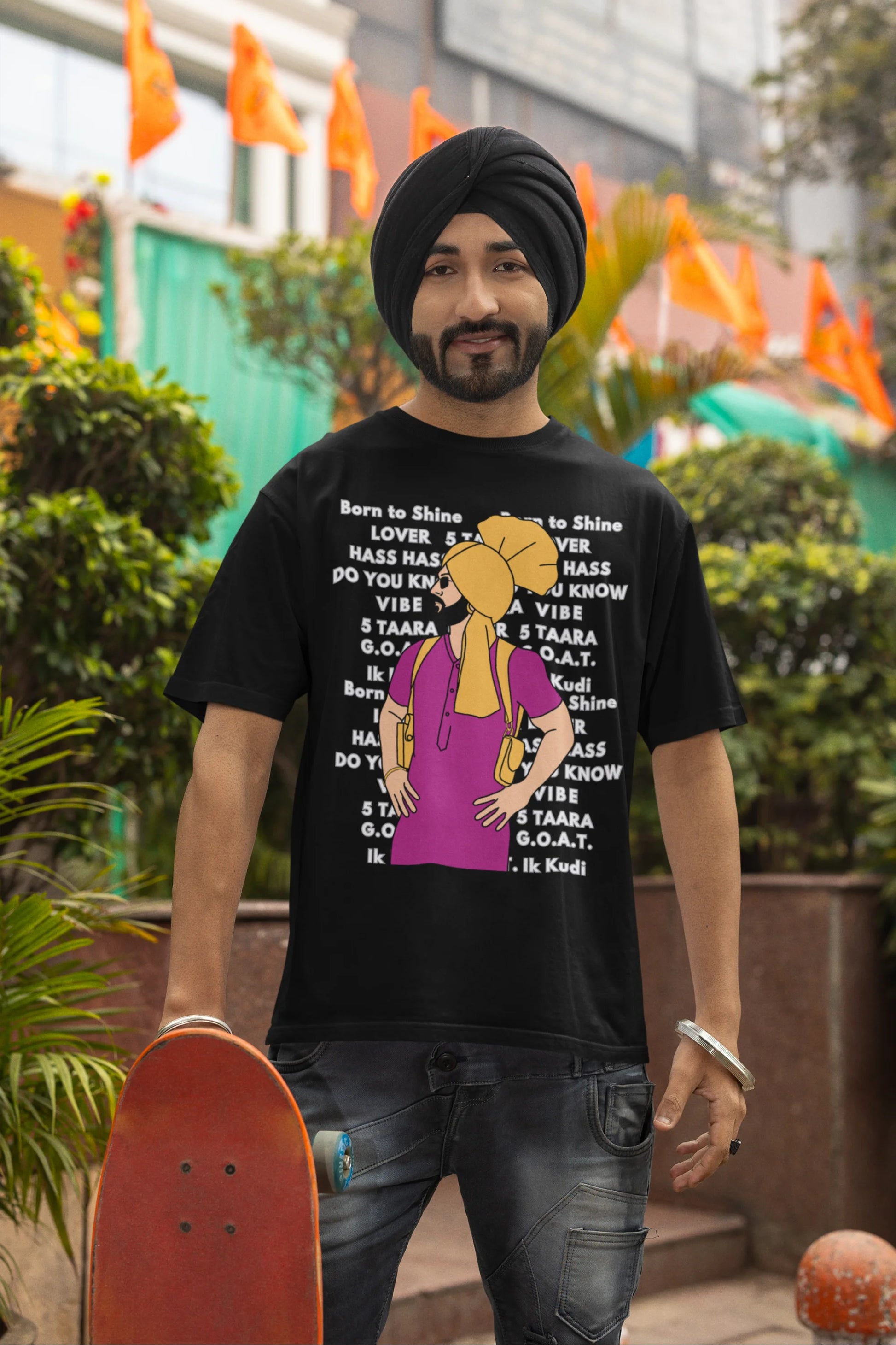 First image of a male model wearing a black oversized t-shirt with a Diljit Dosanjh portrait on a t-shirt with his album titles written in the background.