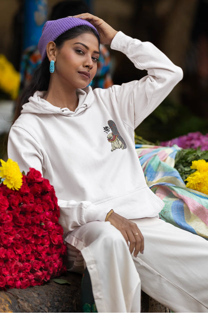 Fifth front view of a female model wearing a cream hoodie with a design of a mythical Japanese dog.