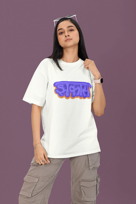  First front view of a female model wearing an off-white oversized t-shirt featuring "Jhakas" in a stylish font.