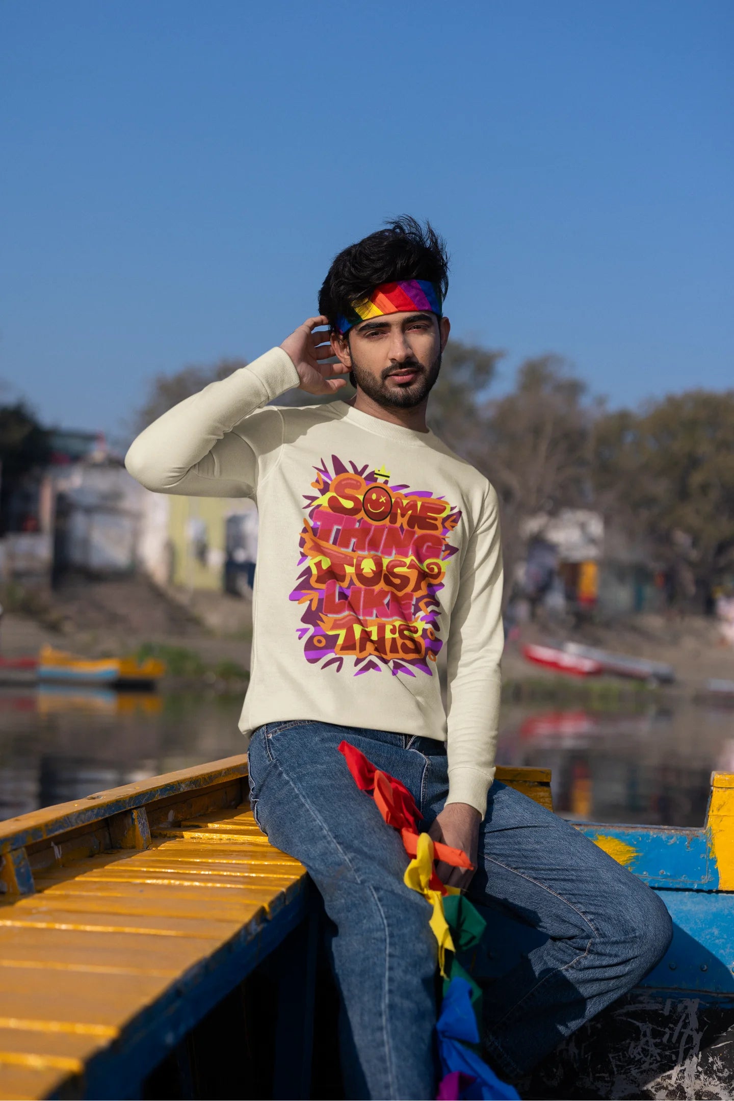 First front view of a male model wearing an cream sweatshirt featuring the designs inspired from Coldplay's "Something Just Like This" music video.
