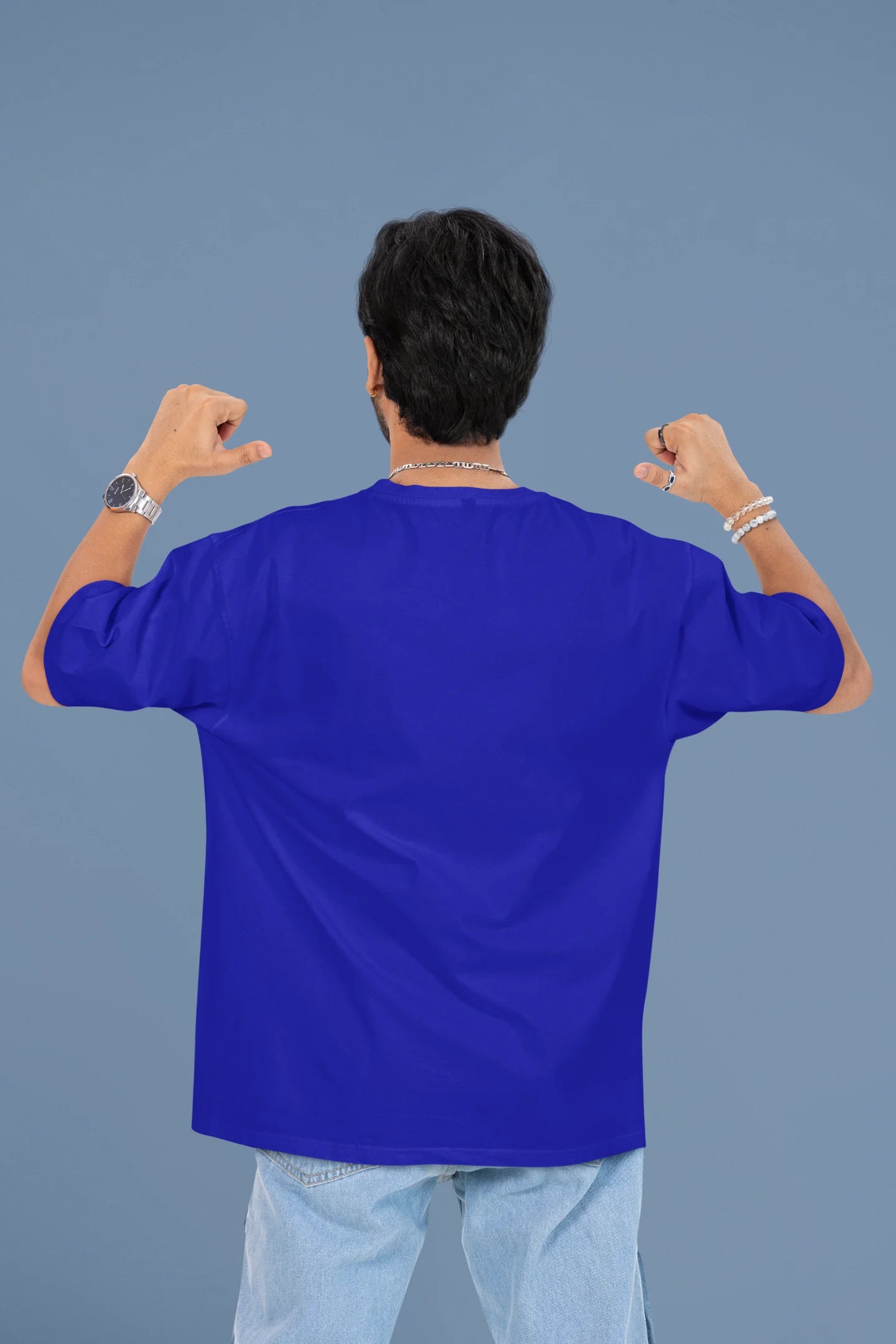 Back view of a male model wearing a royal blue oversized t-shirt with the text "Anti-Valentine's Club" printed on it.