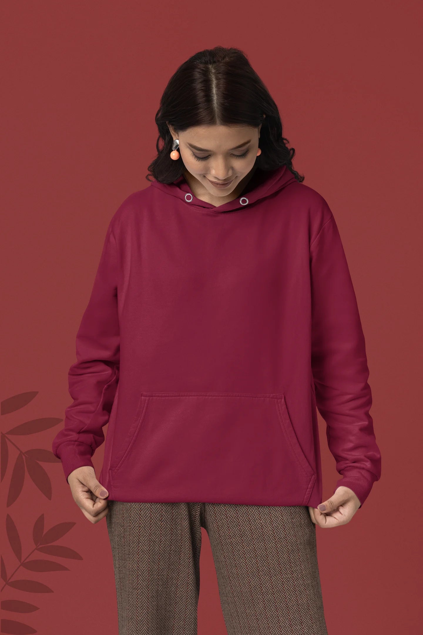 First front view of a female model wearing a maroon hoodie with a heron taking off under the moonlight.