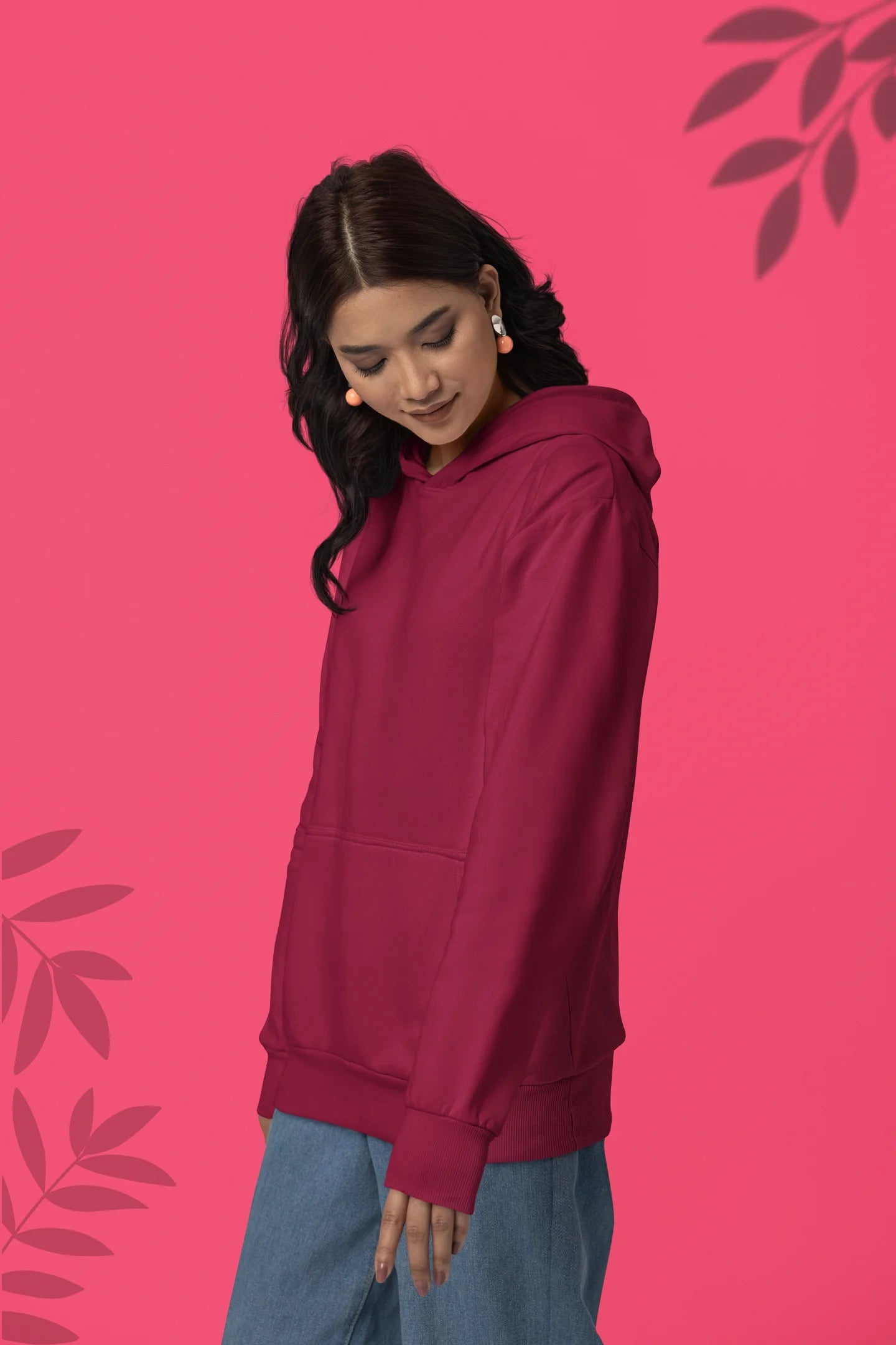 Second front view of a female model wearing a maroon hoodie with a heron taking off under the moonlight.