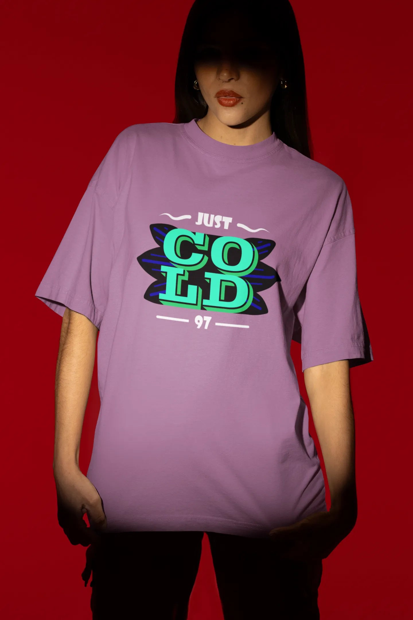 Second front view of a female model wearing an dirty purple oversized t-shirt with the text "Just Cold" printed on it.