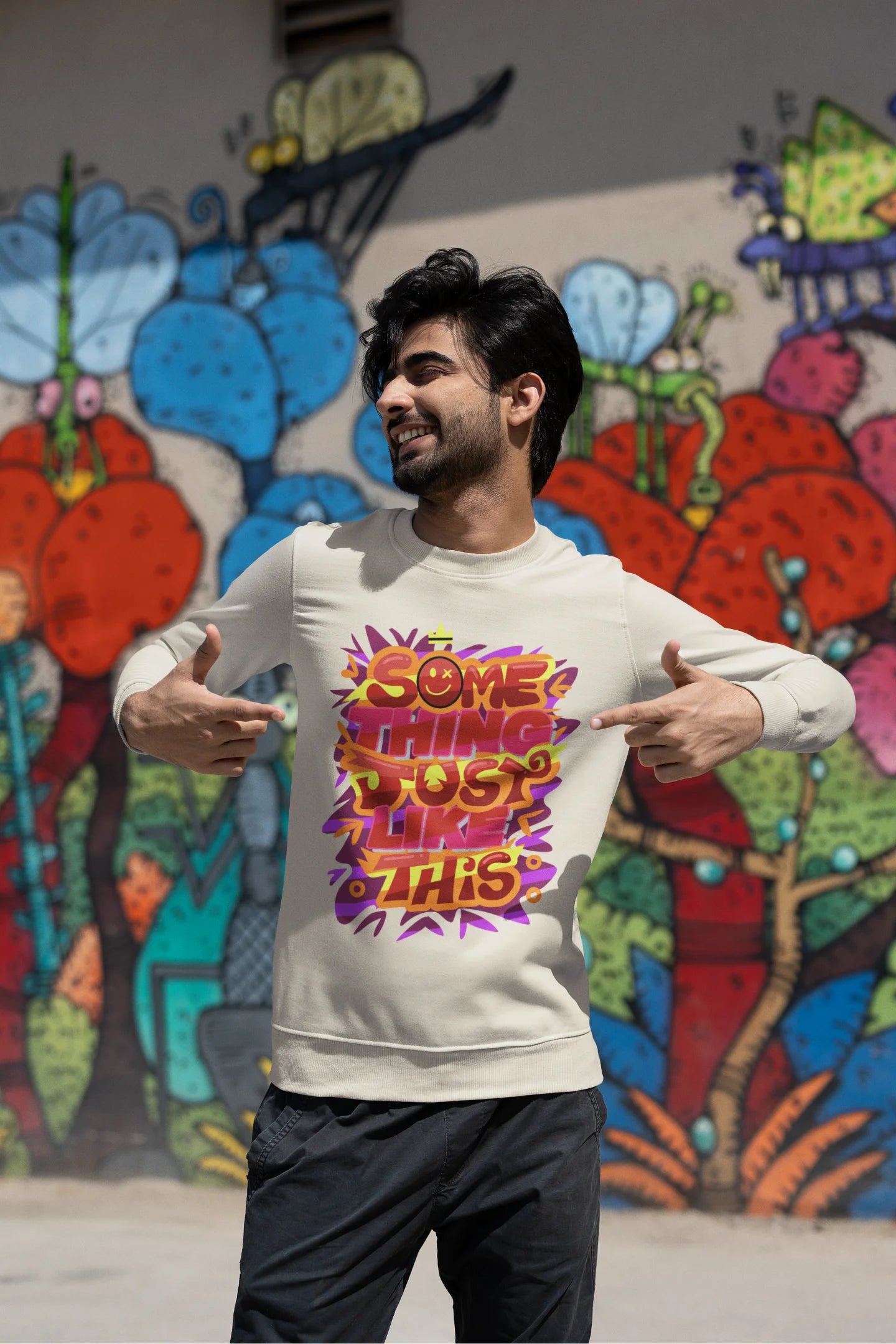 Third front view of a male model wearing an cream sweatshirt featuring the designs inspired from Coldplay's "Something Just Like This" music video.