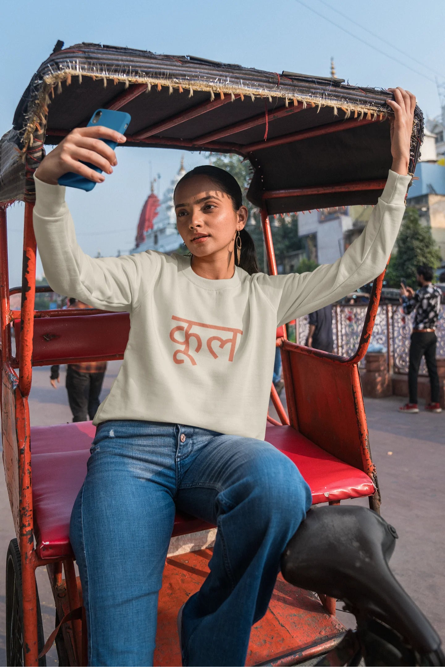 5th front view of a female model wearing a cream oversized t-shirt featuring the Hindi word for "cool" with a unique, playful design.