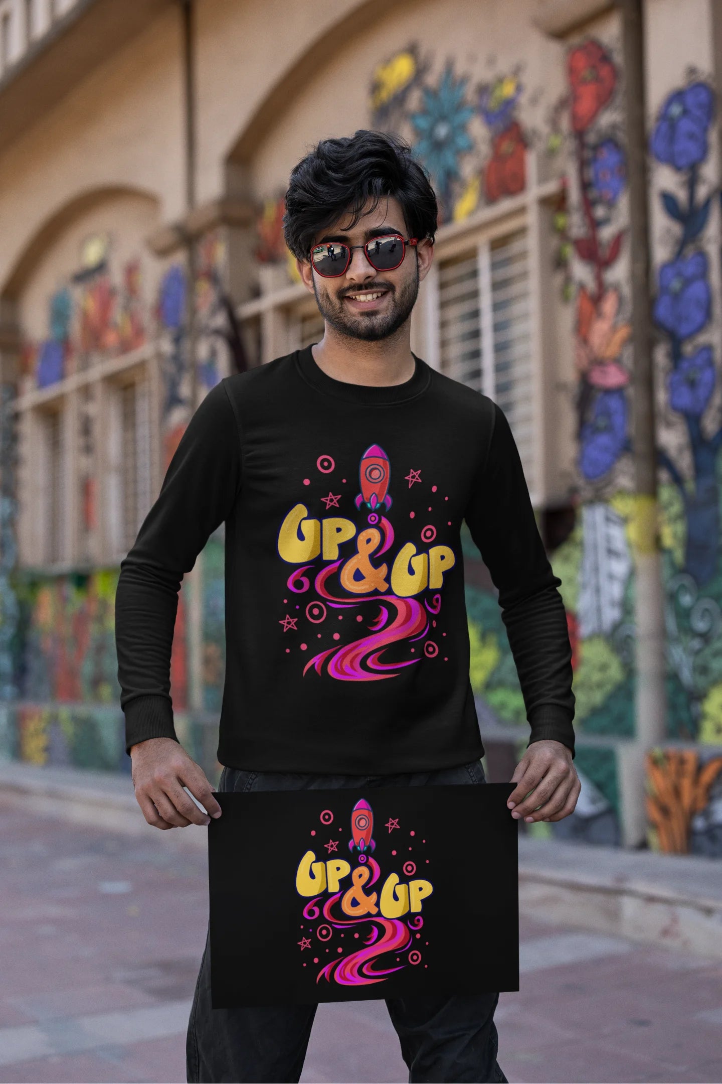 First front view of a male model wearing an black sweatshirt with a rocket ship design and the text "Up & Up".