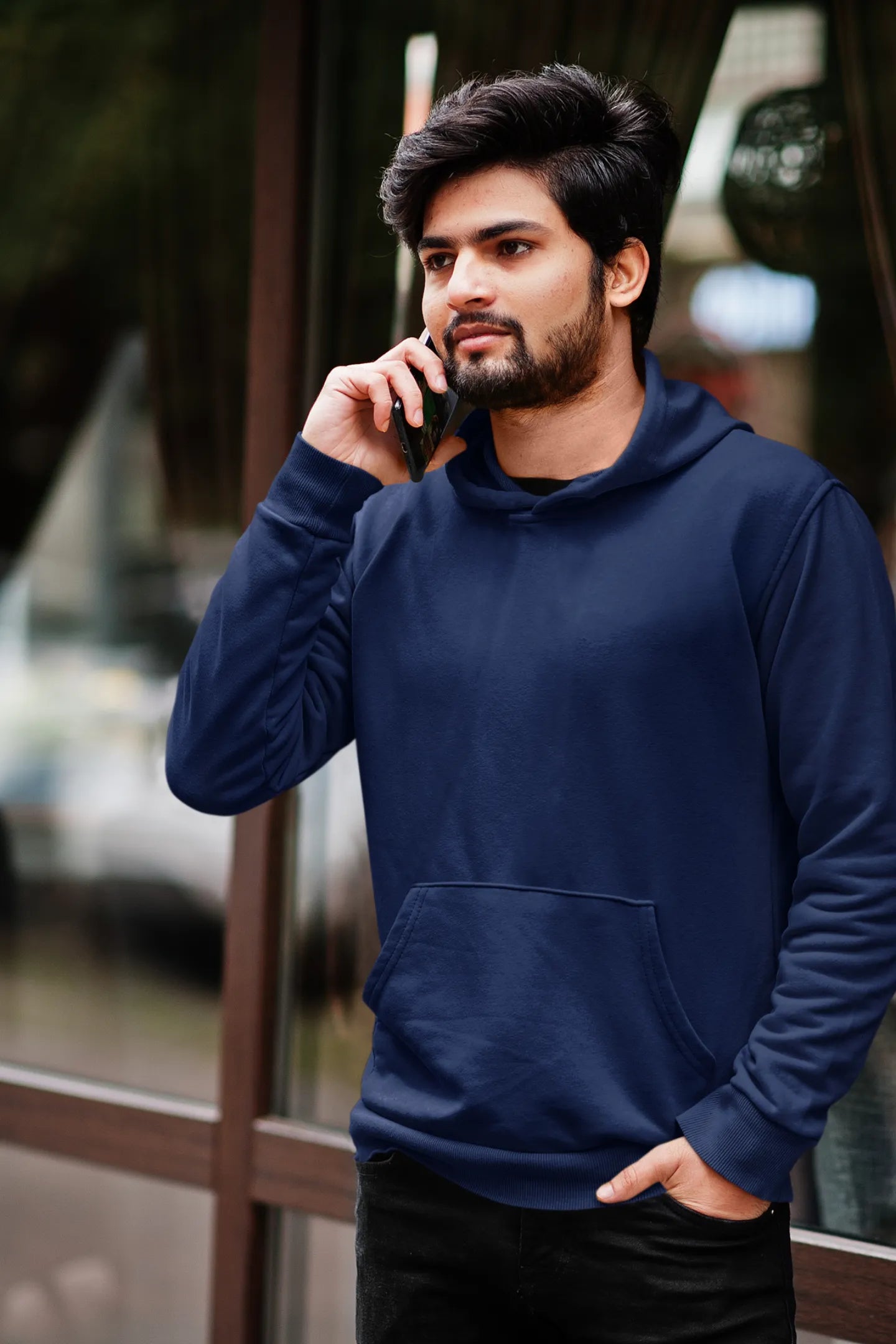 Fourth front view of a male model wearing a navy blue hoodie featuring a Range Rover Defender design, exuding power and ruggedness.