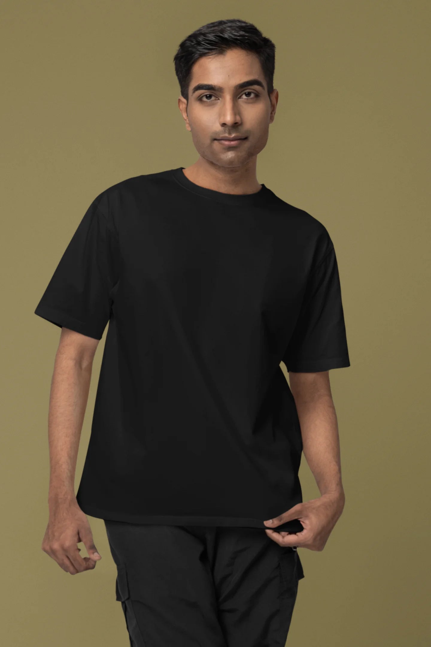 Front view of a male model wearing a black oversized tee with a heron taking off under the moonlight.