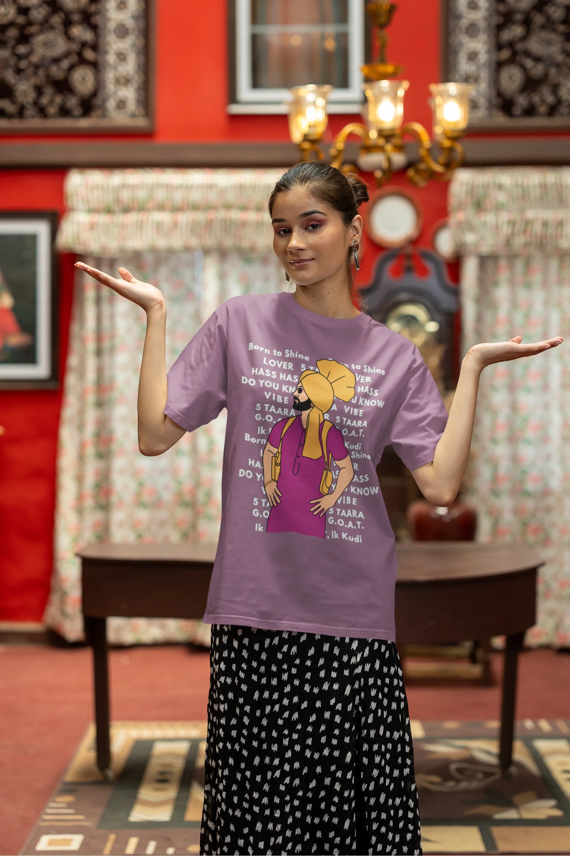 Third image of a female model wearing a dirty purple oversized t-shirt with a Diljit Dosanjh portrait on a t-shirt with his album titles written in the background.