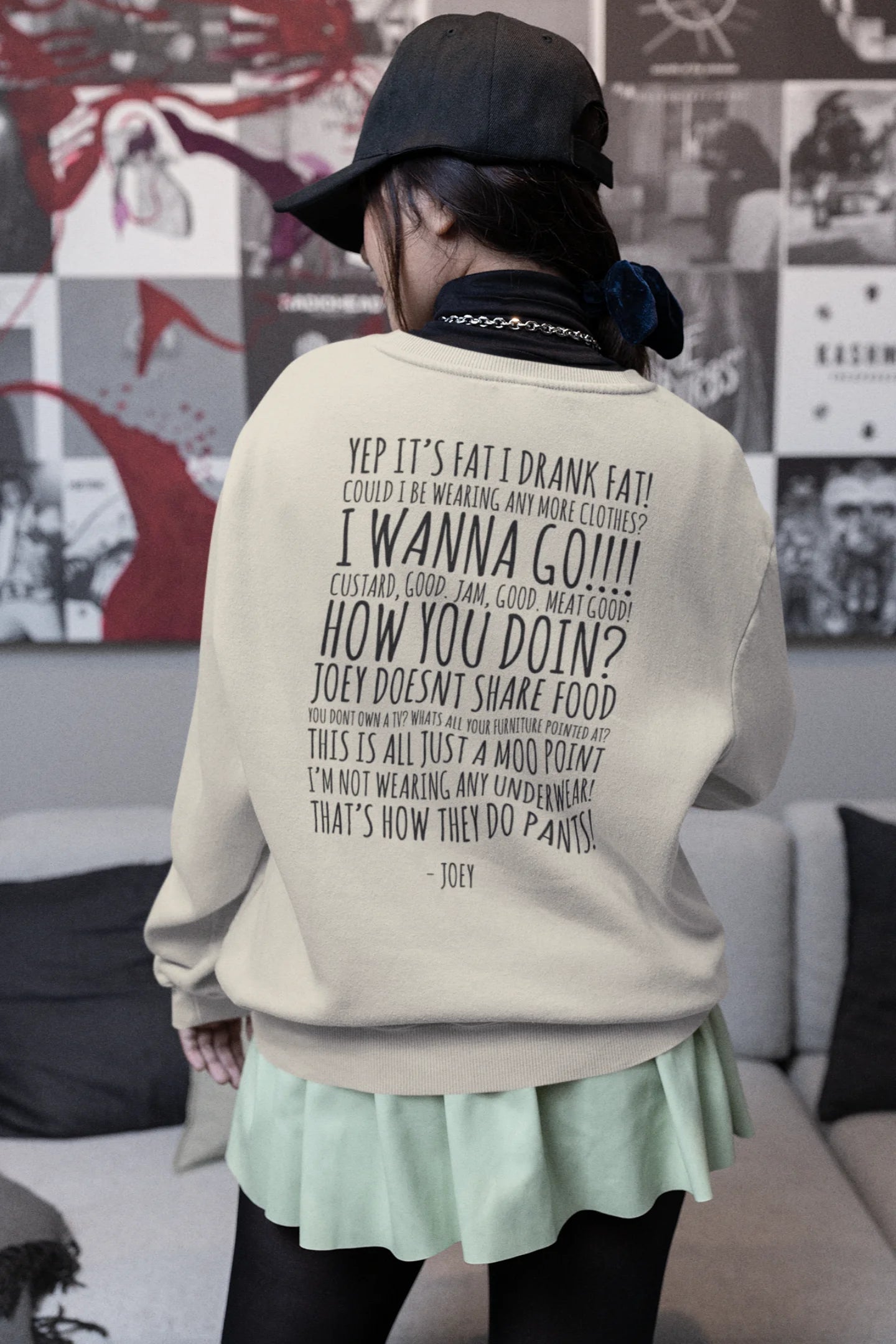 Back view of female model wearing a cream F.R.I.E.N.D.S. sweatshirt featuring a design inspired by Joey Tribbiani's funny quotes and signature charm.