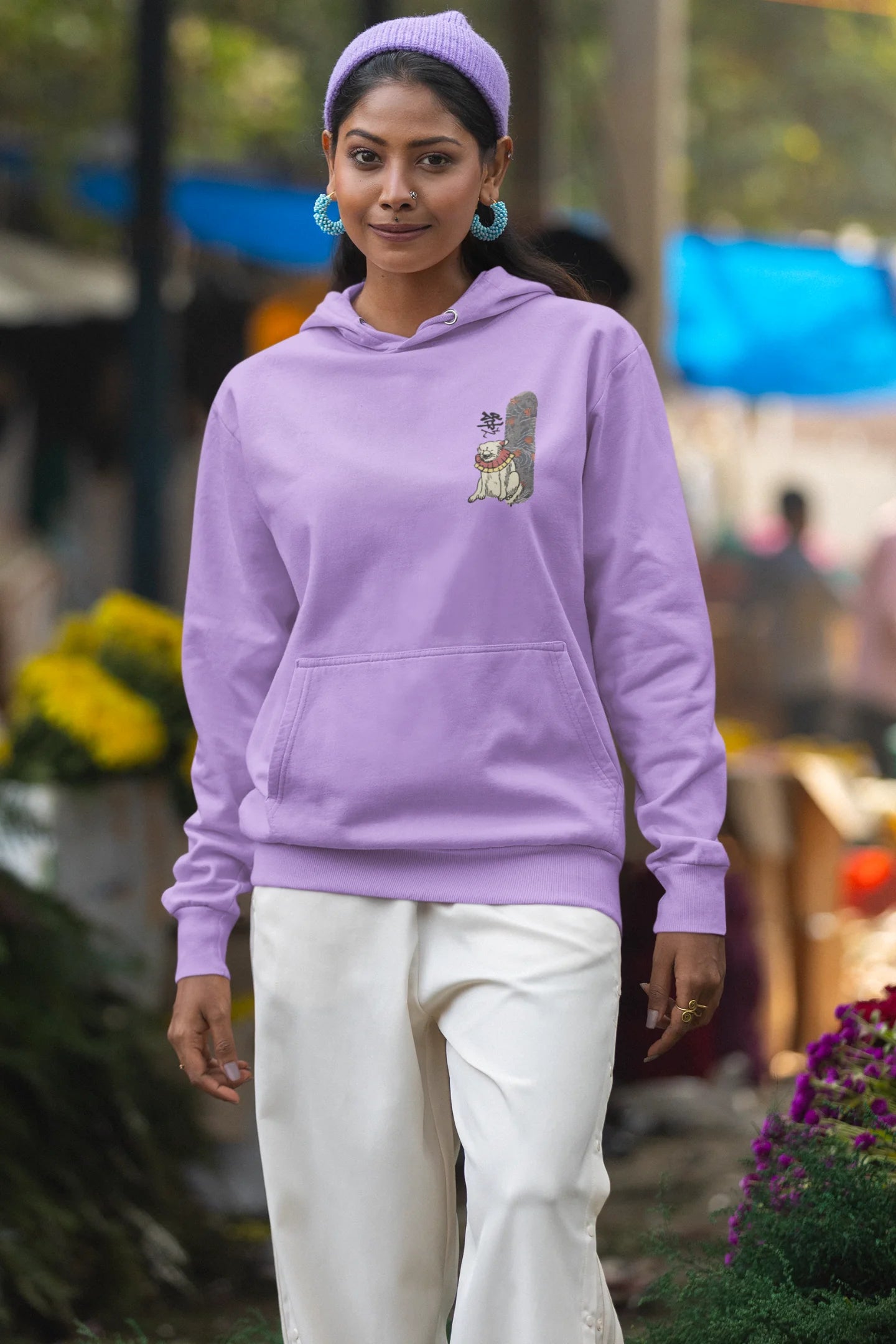 First front view of a female model wearing a lavender hoodie with a design of a mythical Japanese dog.