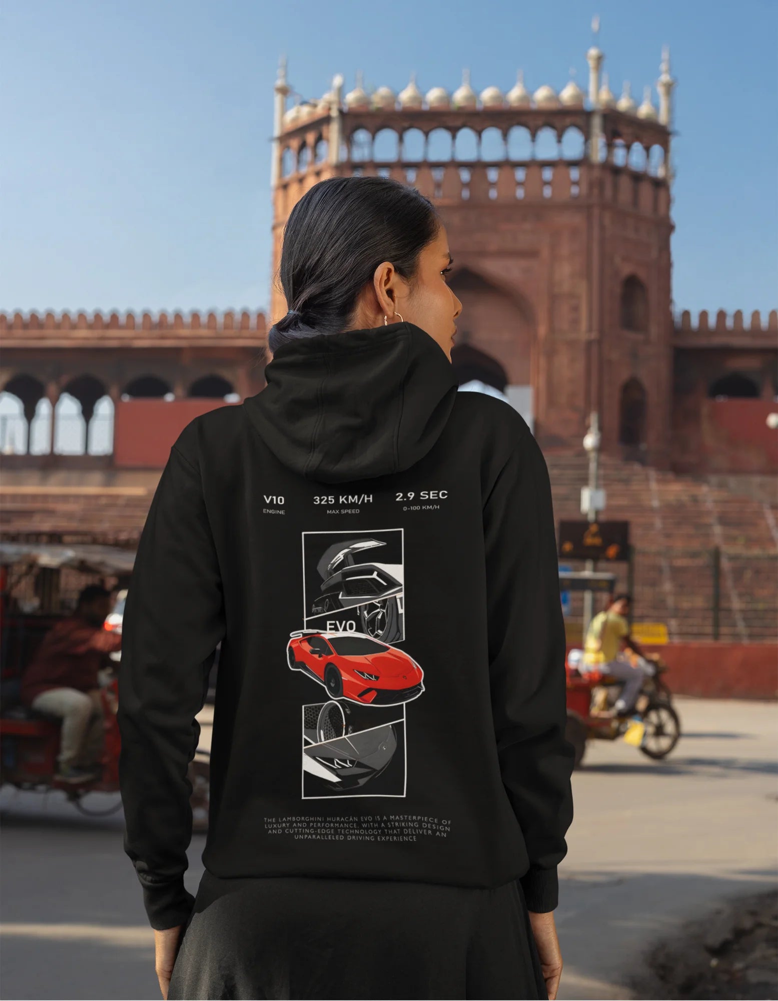 Back view of a female model wearing a black hoodie featuring a Lamborghini Huracan design, exuding speed and power.