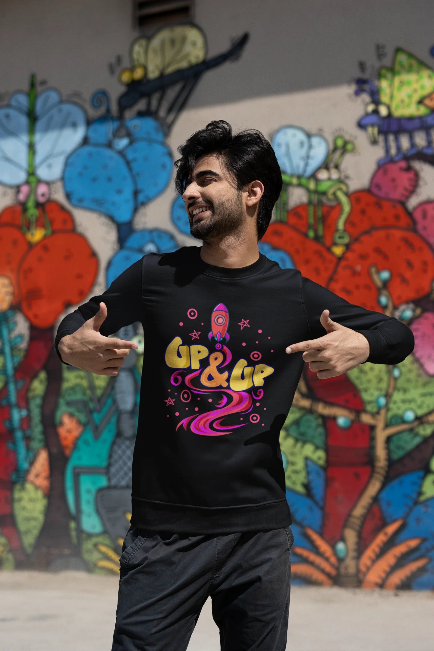Second front view of a male model wearing an black sweatshirt with a rocket ship design and the text "Up & Up".