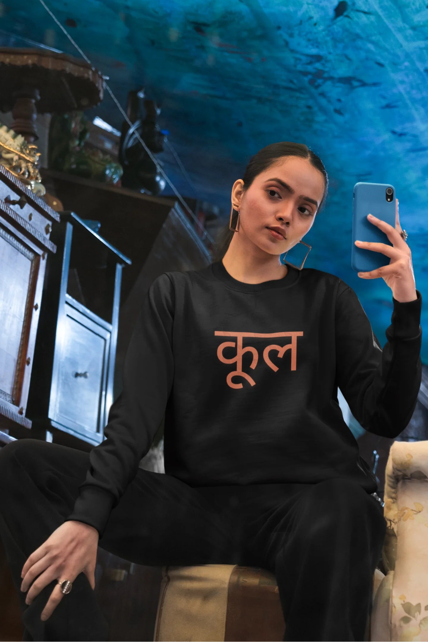 2nd front view of a female model wearing a black oversized t-shirt featuring the Hindi word for "cool" with a unique, playful design.