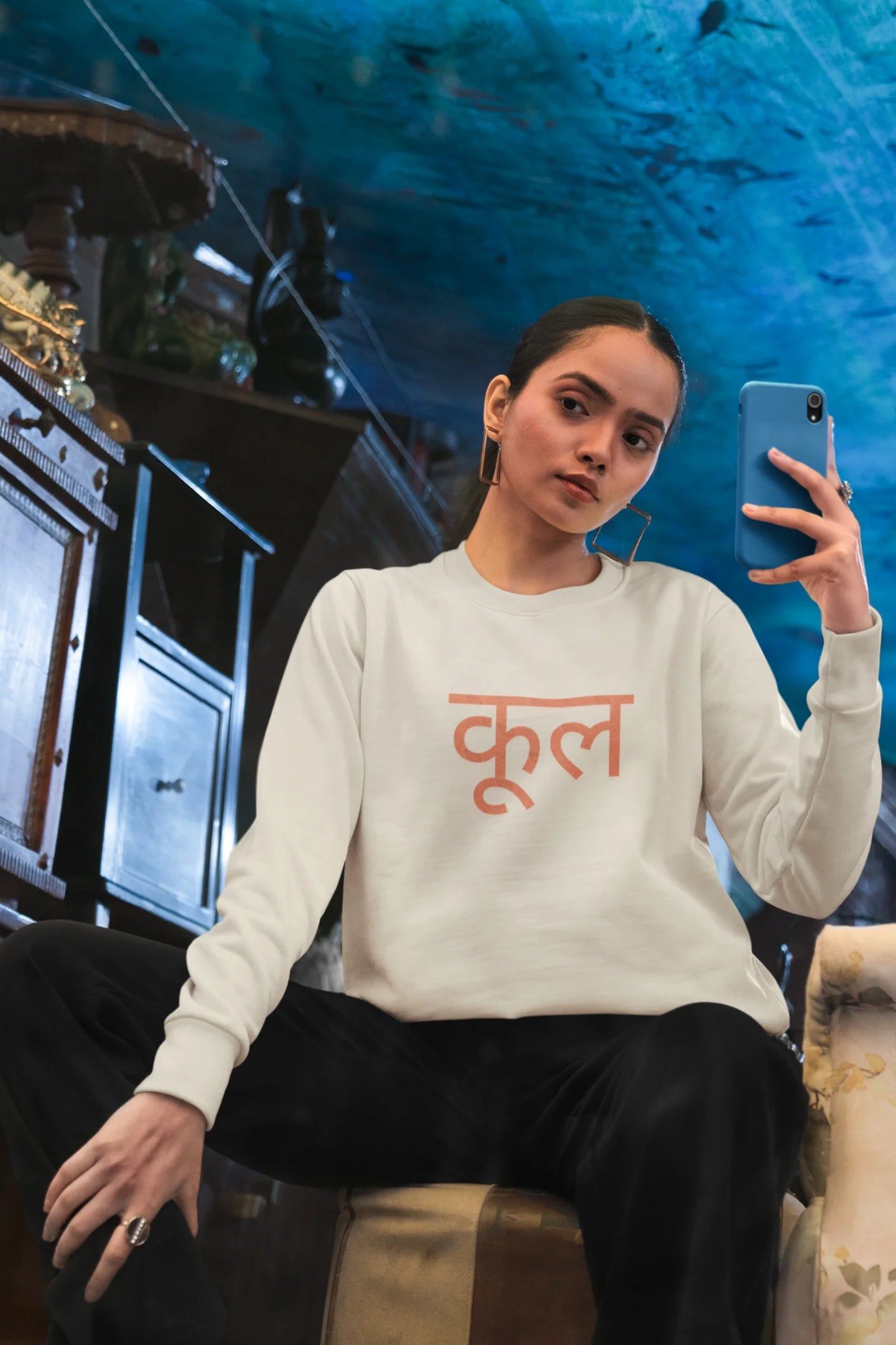 4th front view of a female model wearing a cream oversized t-shirt featuring the Hindi word for "cool" with a unique, playful design.
