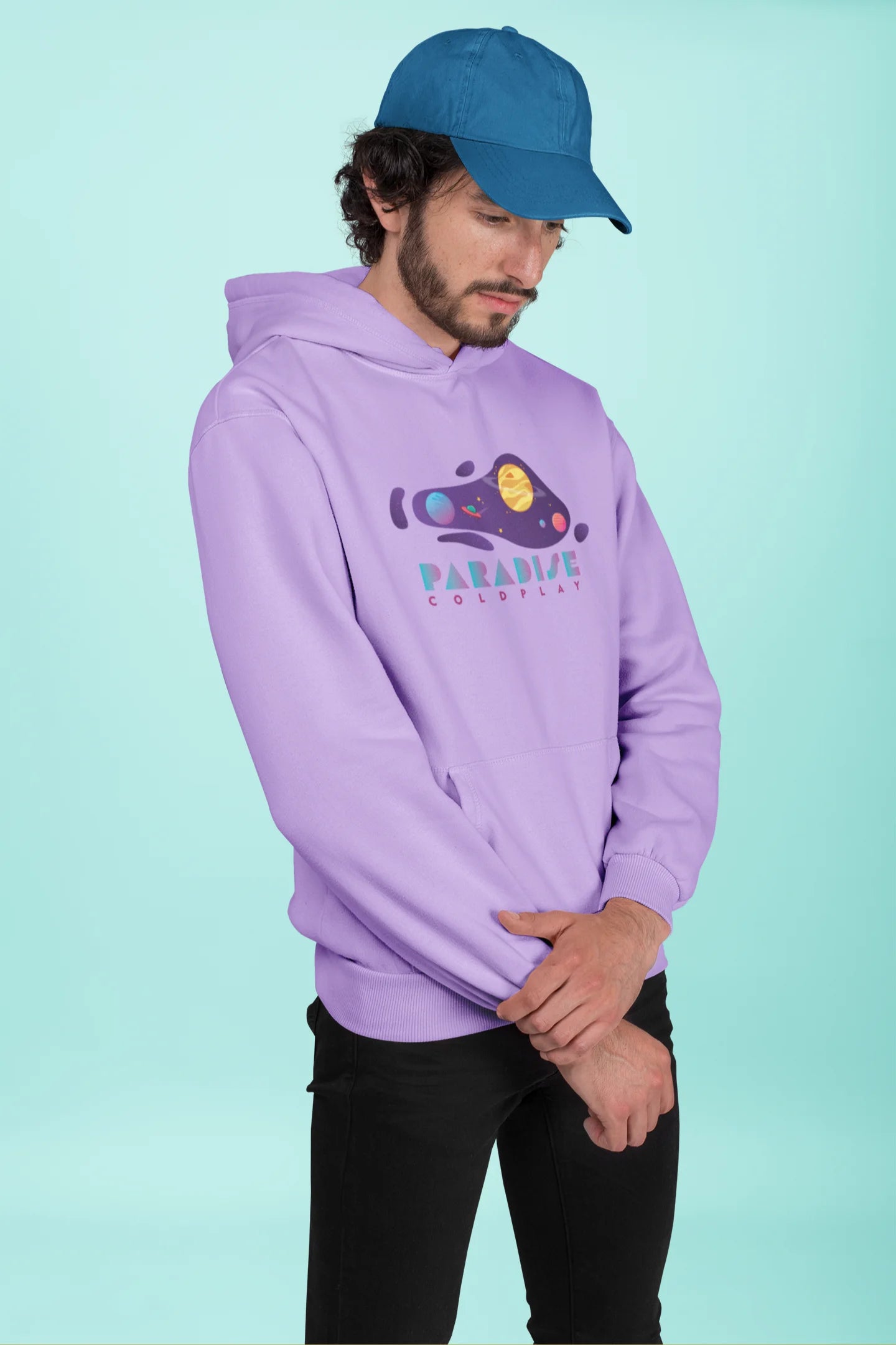 2nd front view of a male model wearing an lavender hoodie with the "Paradise" album artwork by Coldplay.