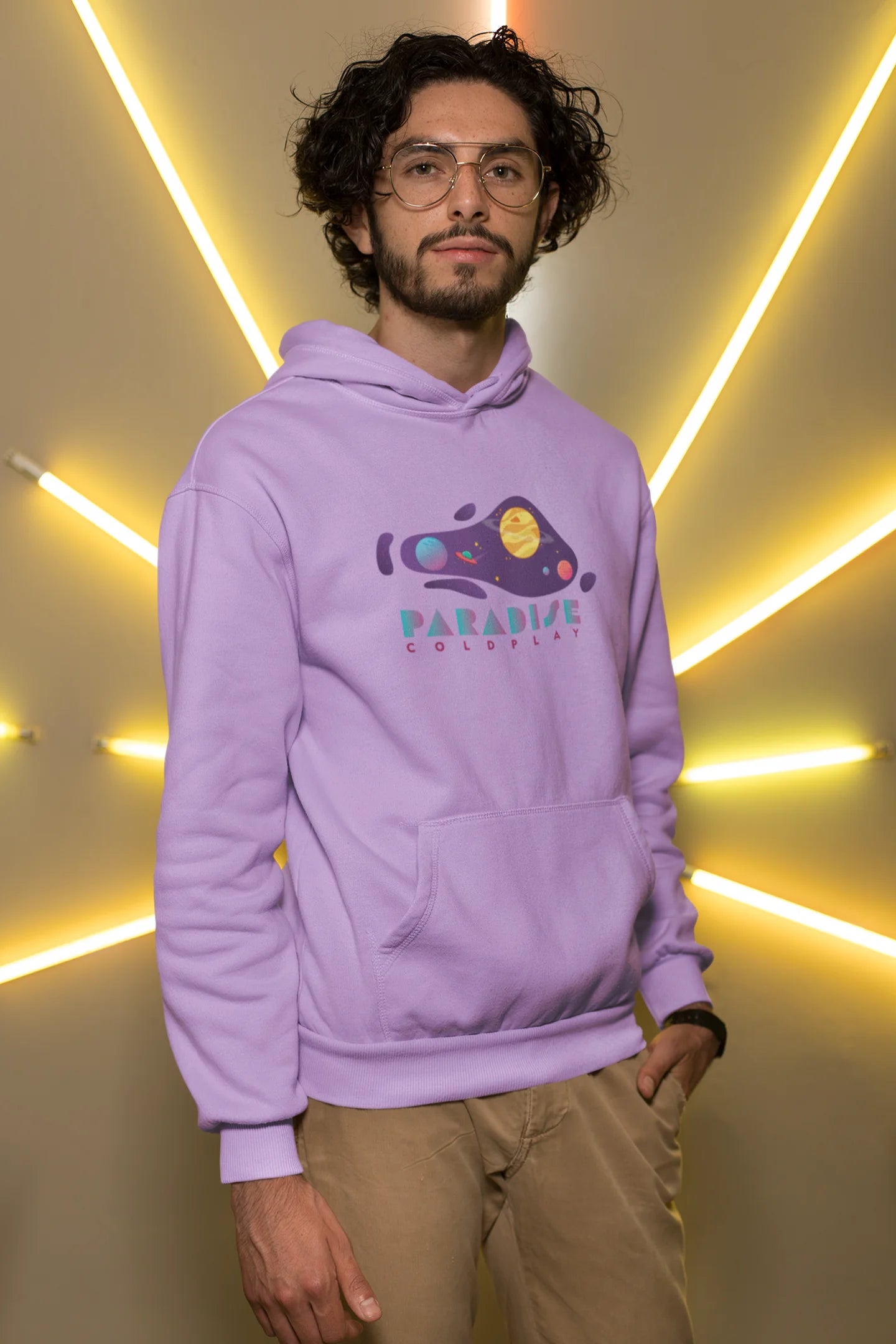 First front view of a male model wearing an lavender hoodie with the "Paradise" album artwork by Coldplay.