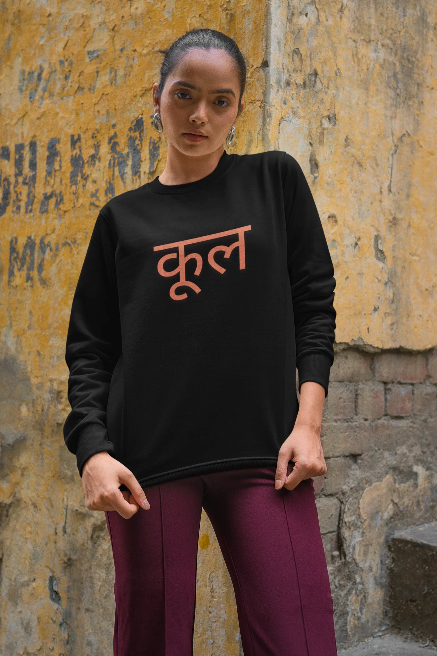 4th front view of a female model wearing a black oversized t-shirt featuring the Hindi word for "cool" with a unique, playful design.