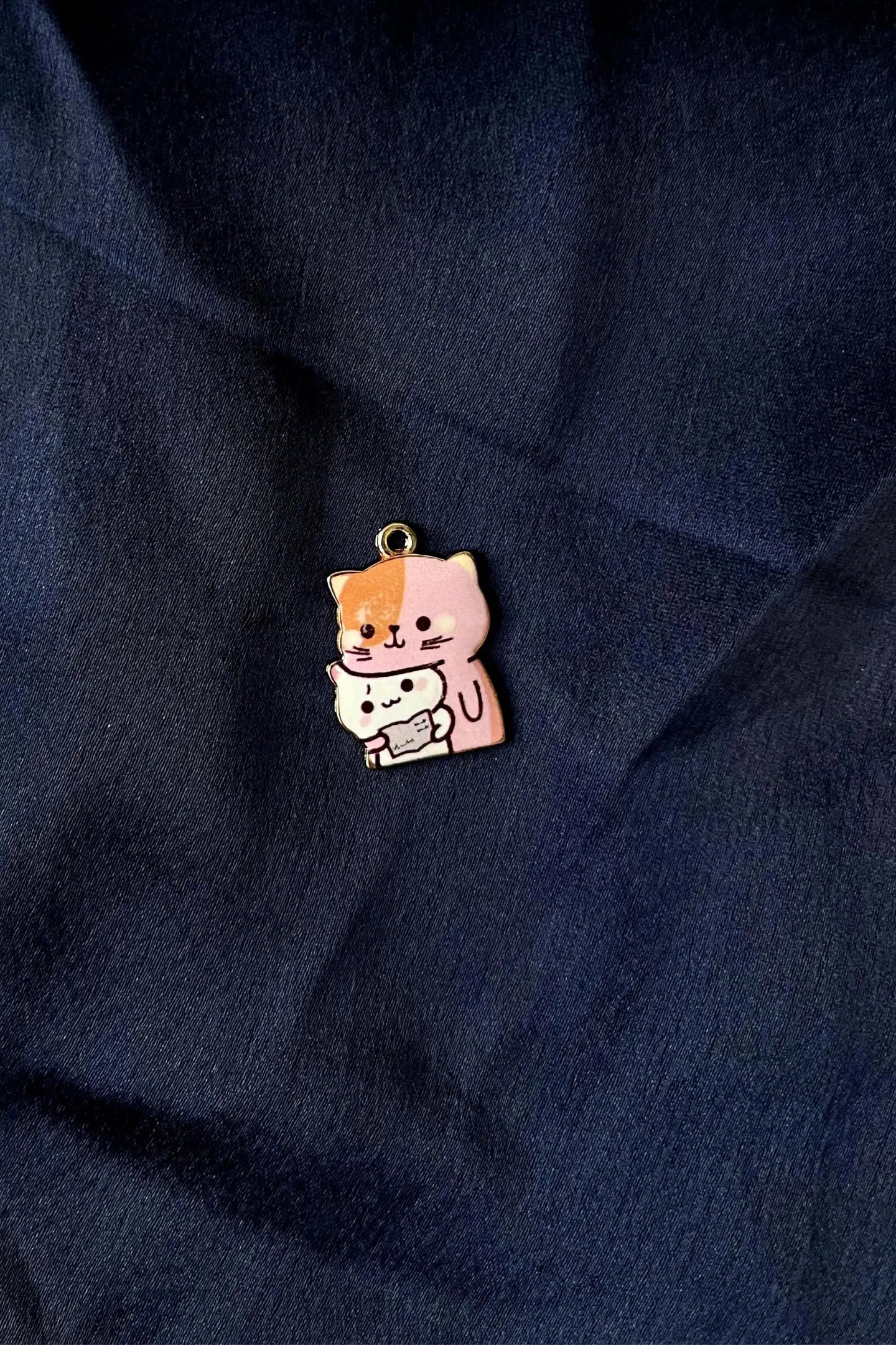 Second view of a charm featuring a design of a mother cat and her kitten.