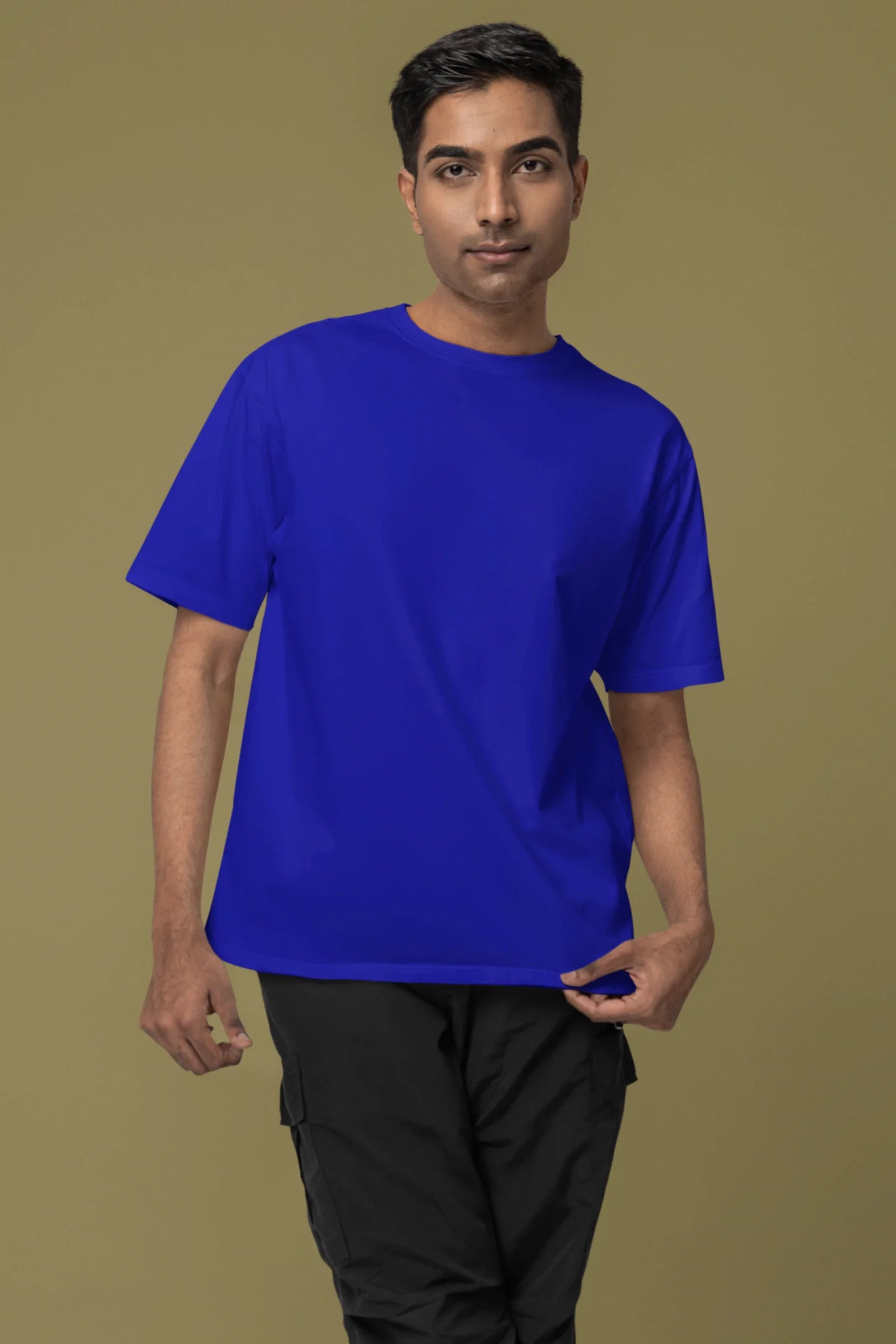 Front view of a male model wearing a royal blue oversized tee with a heron taking off under the moonlight.