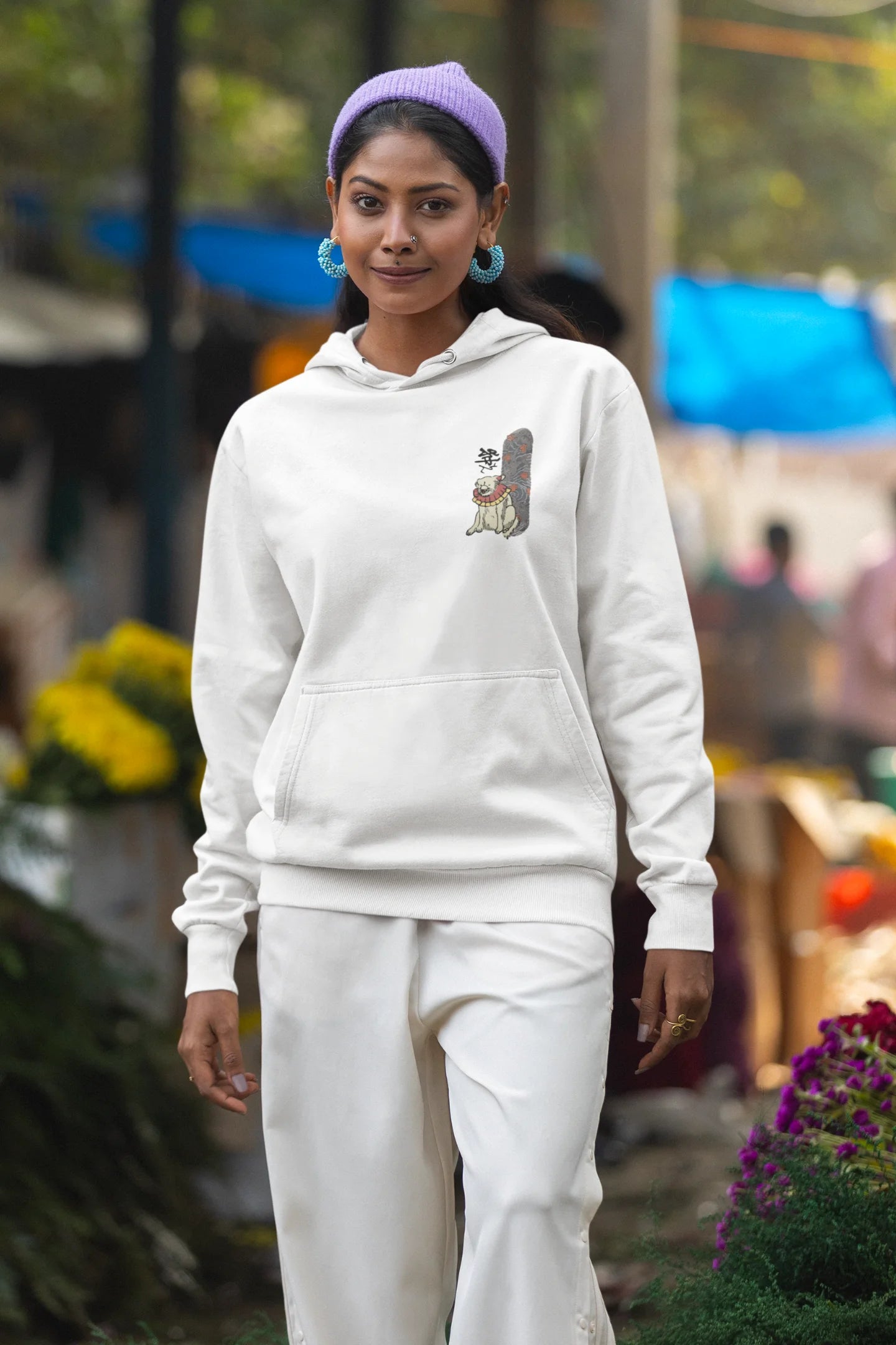 Second front view of a female model wearing a cream hoodie with a design of a mythical Japanese dog.