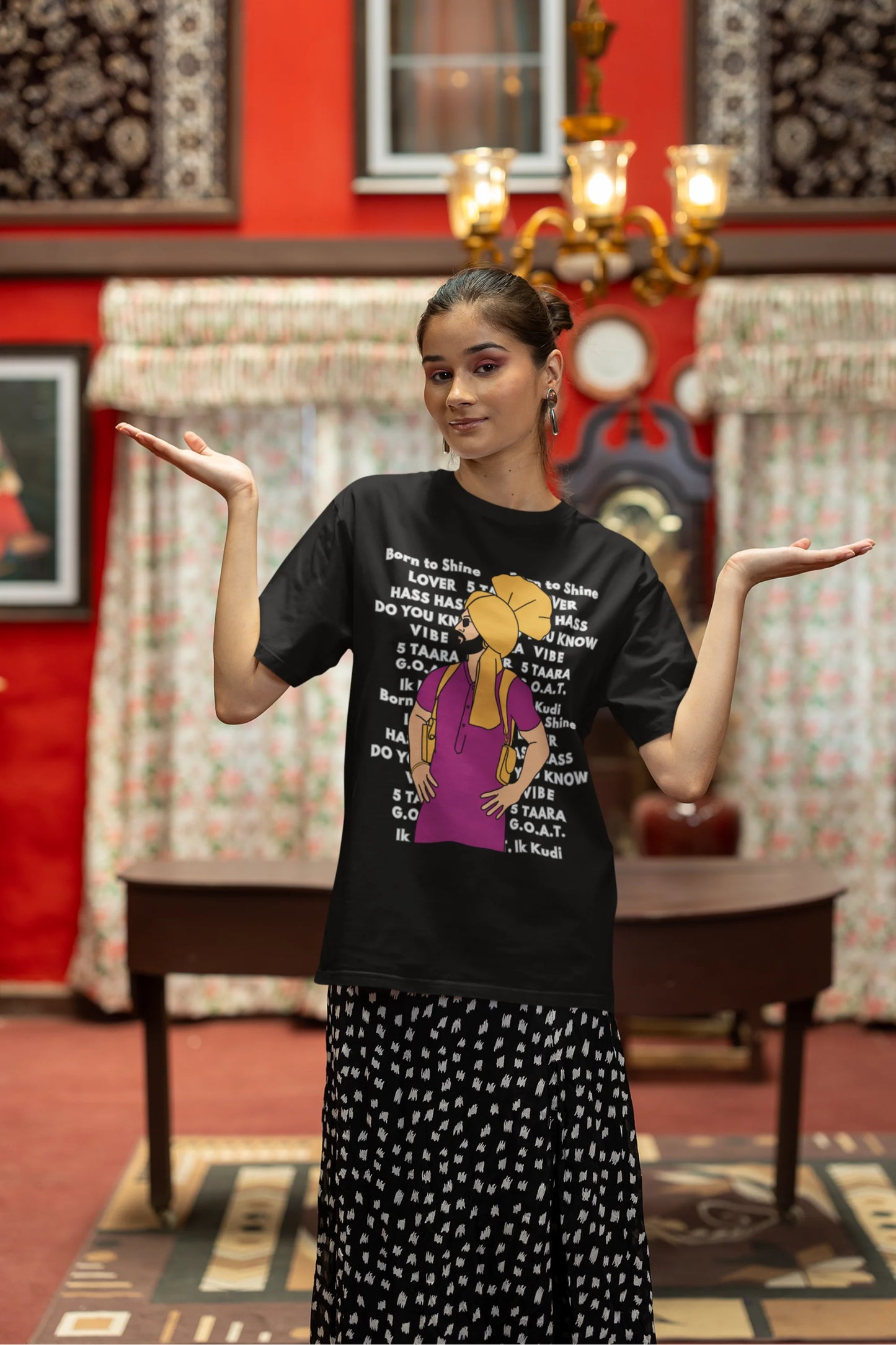 Second image of a female model wearing a black oversized t-shirt with a Diljit Dosanjh portrait on a t-shirt with his album titles written in the background.