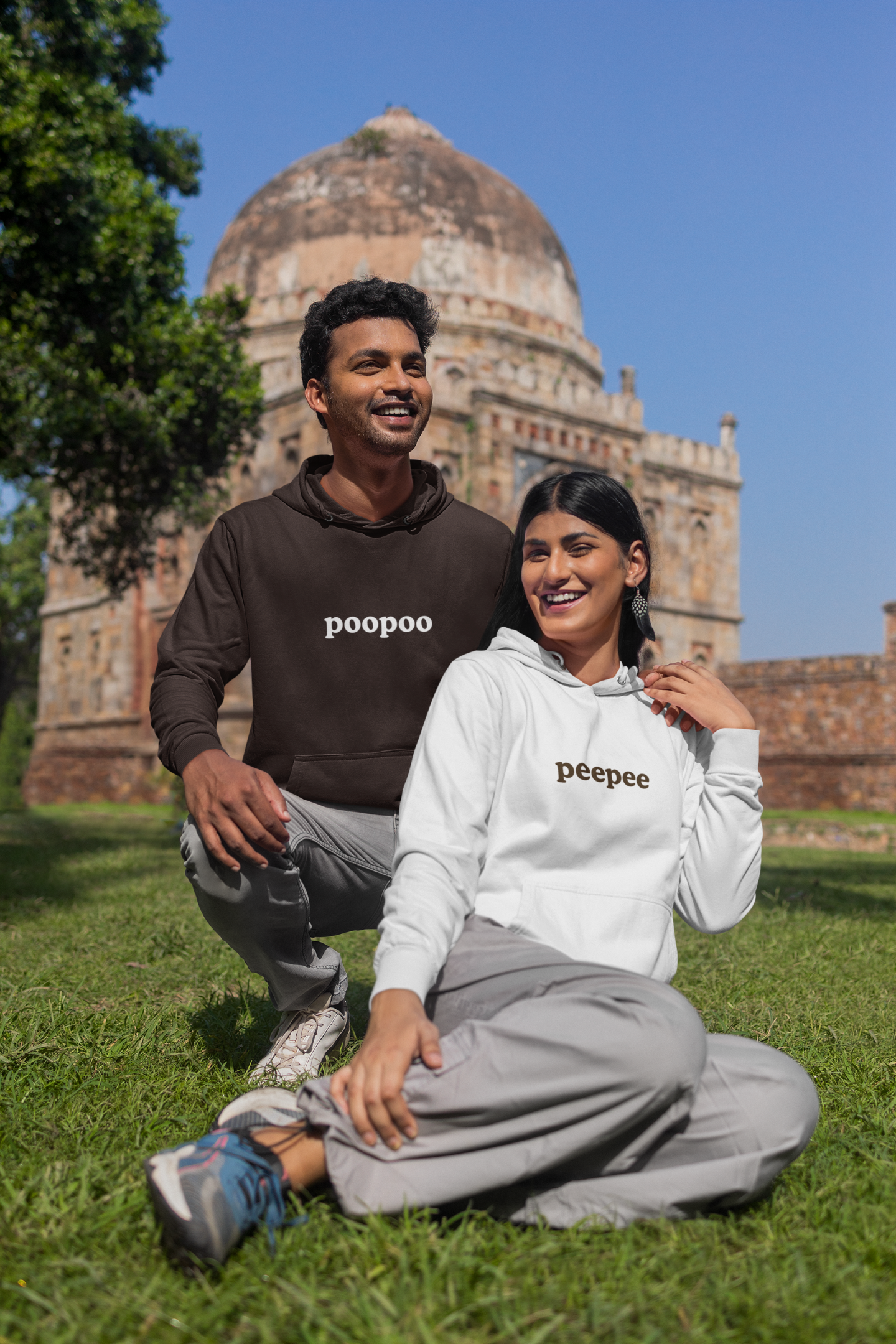First front view of a couple wearing matching hoodies, one with the word "PeePee" and the other with the word "PooPoo".