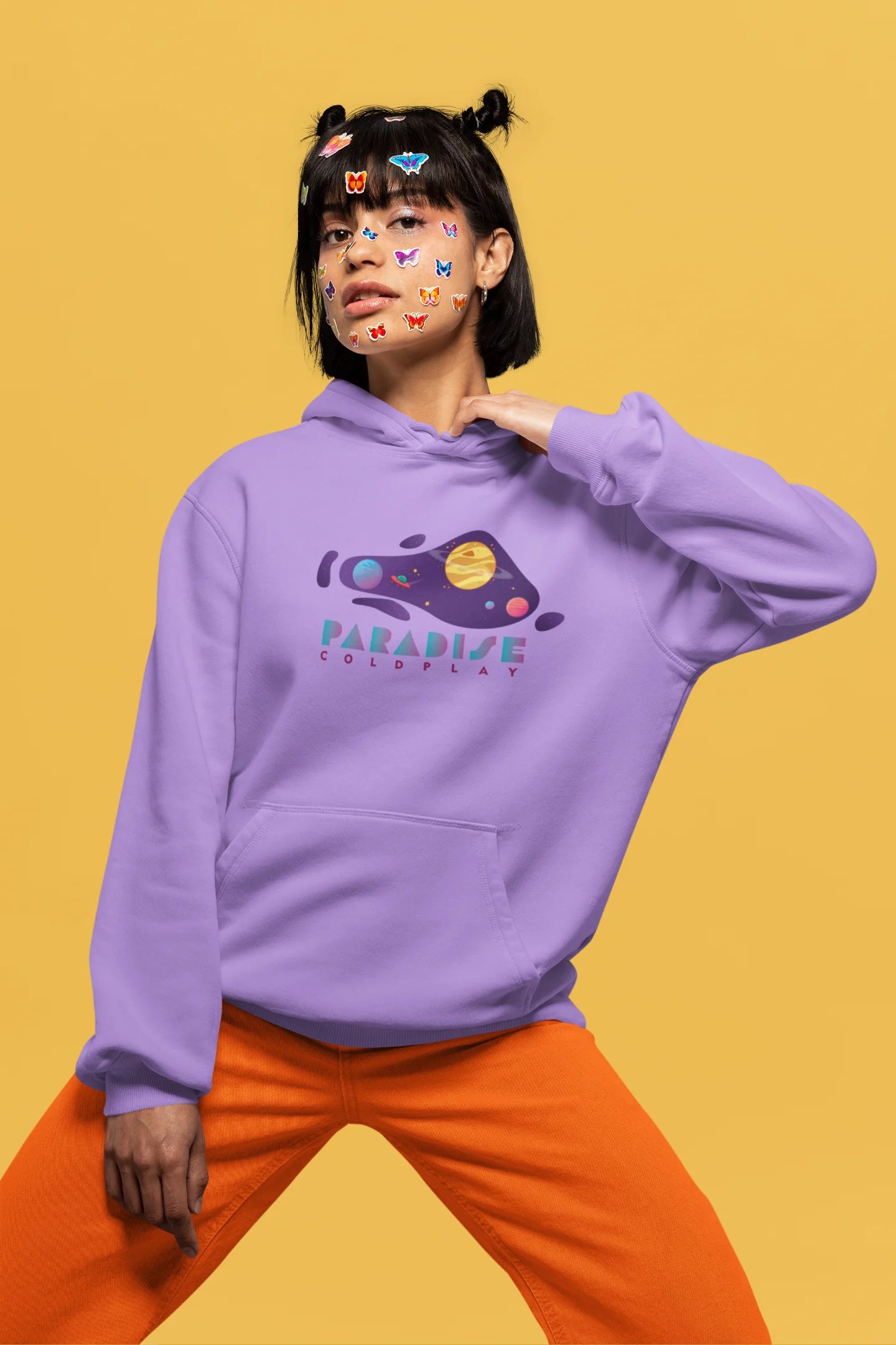 First front view of a female model wearing an lavender hoodie with the "Paradise" album artwork by Coldplay.
