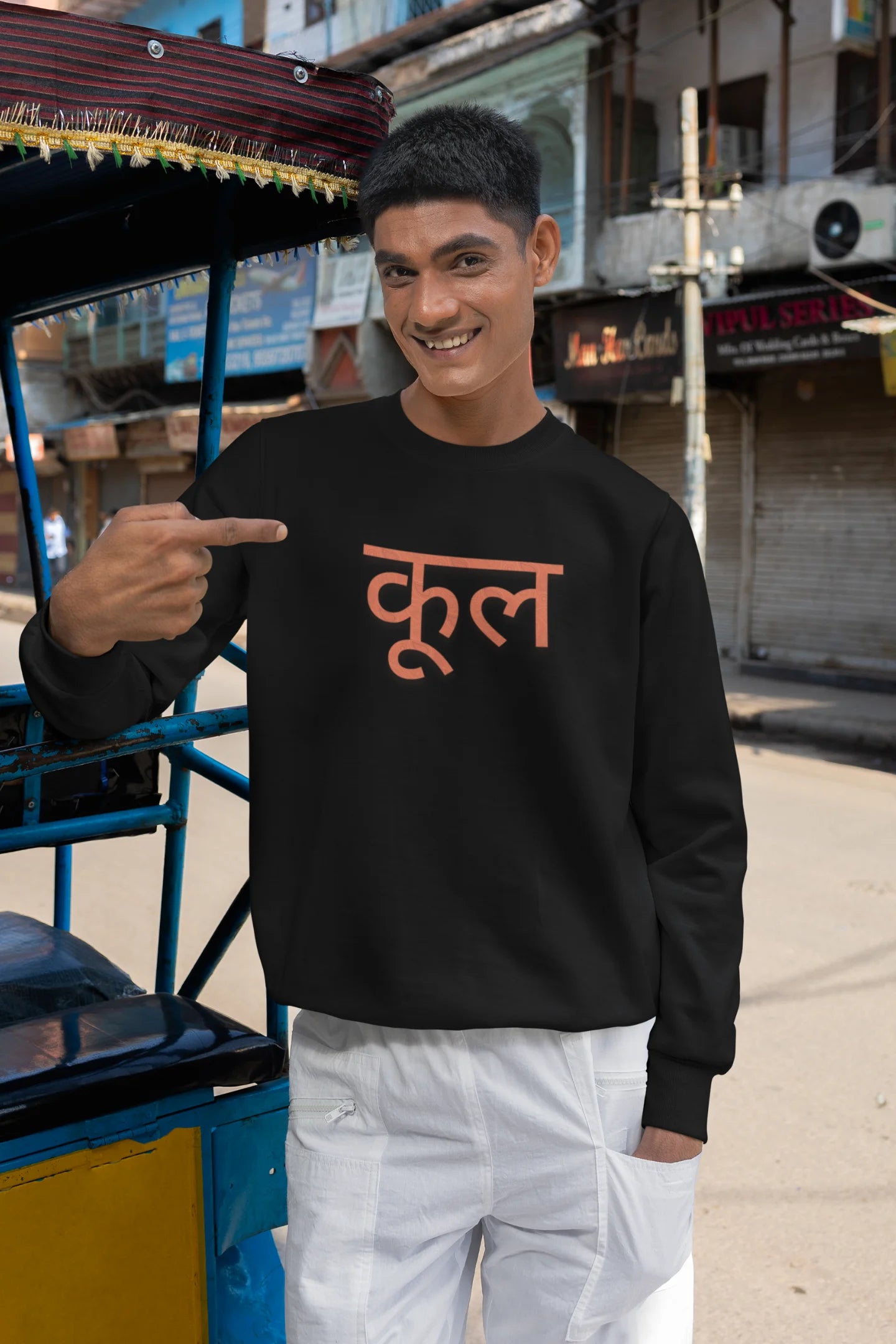 3rd front view of a male model wearing a black oversized t-shirt featuring the Hindi word for "cool" with a unique, playful design.