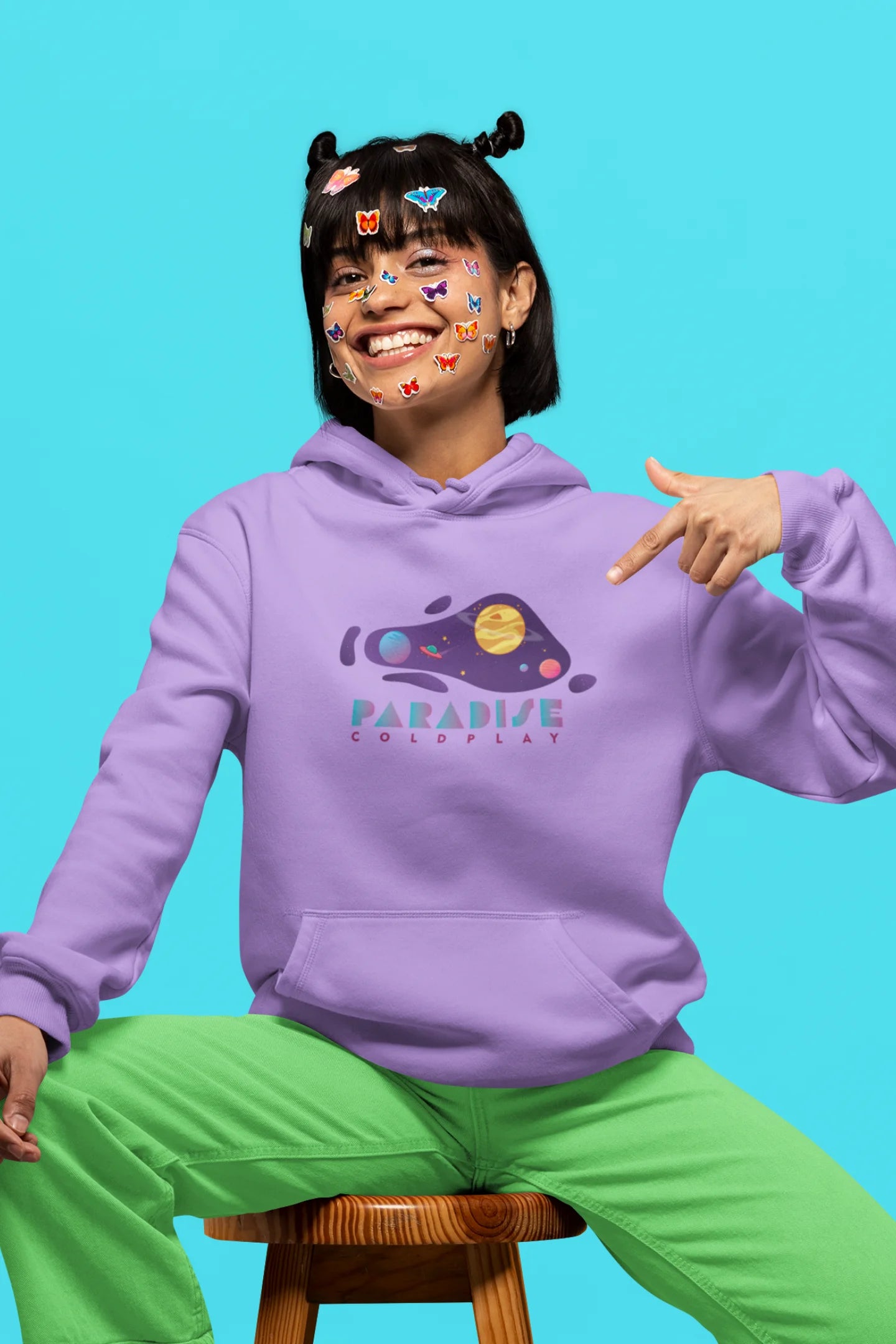 3rd front view of a female model wearing an lavender hoodie with the "Paradise" album artwork by Coldplay.