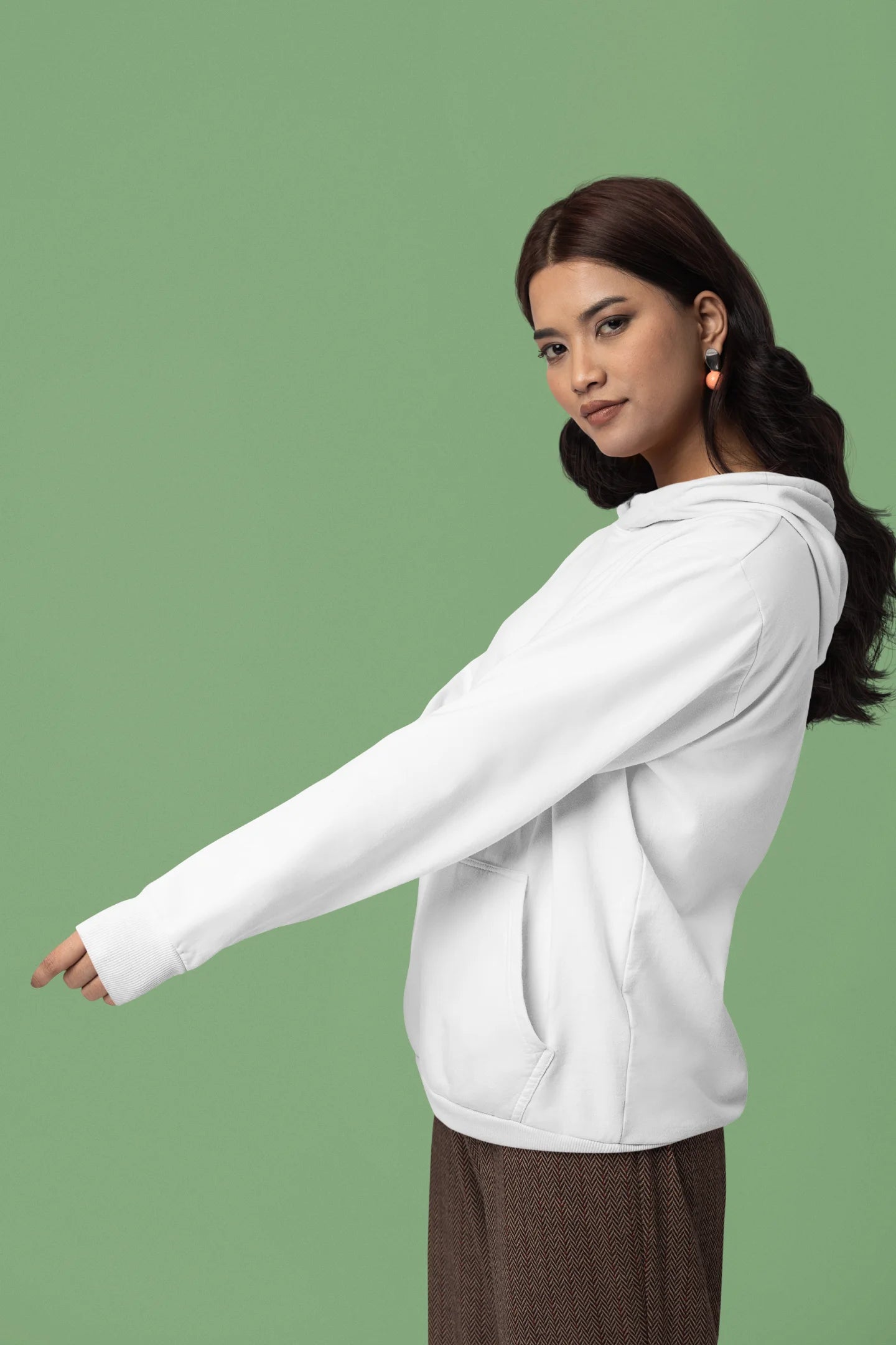 Third front view of a female model wearing a white hoodie with a design of a cat dressed as a samurai, standing against a backdrop of waves and a rising sun.