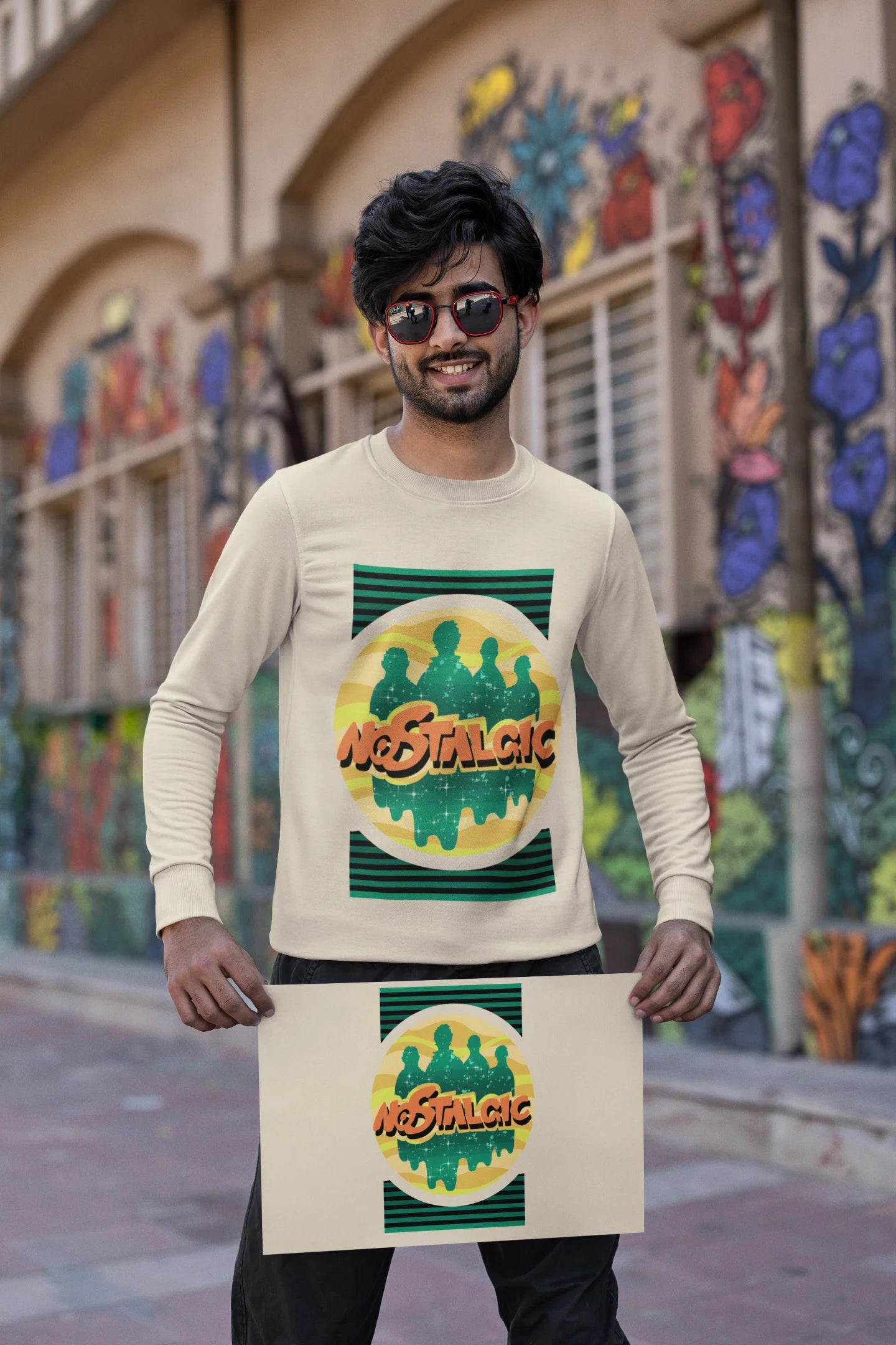 Second view of a male model wearing an oversized cream sweatshirt with a shadow silhouette of the Coldplay band members and the word "Nostalgic" printed on it.