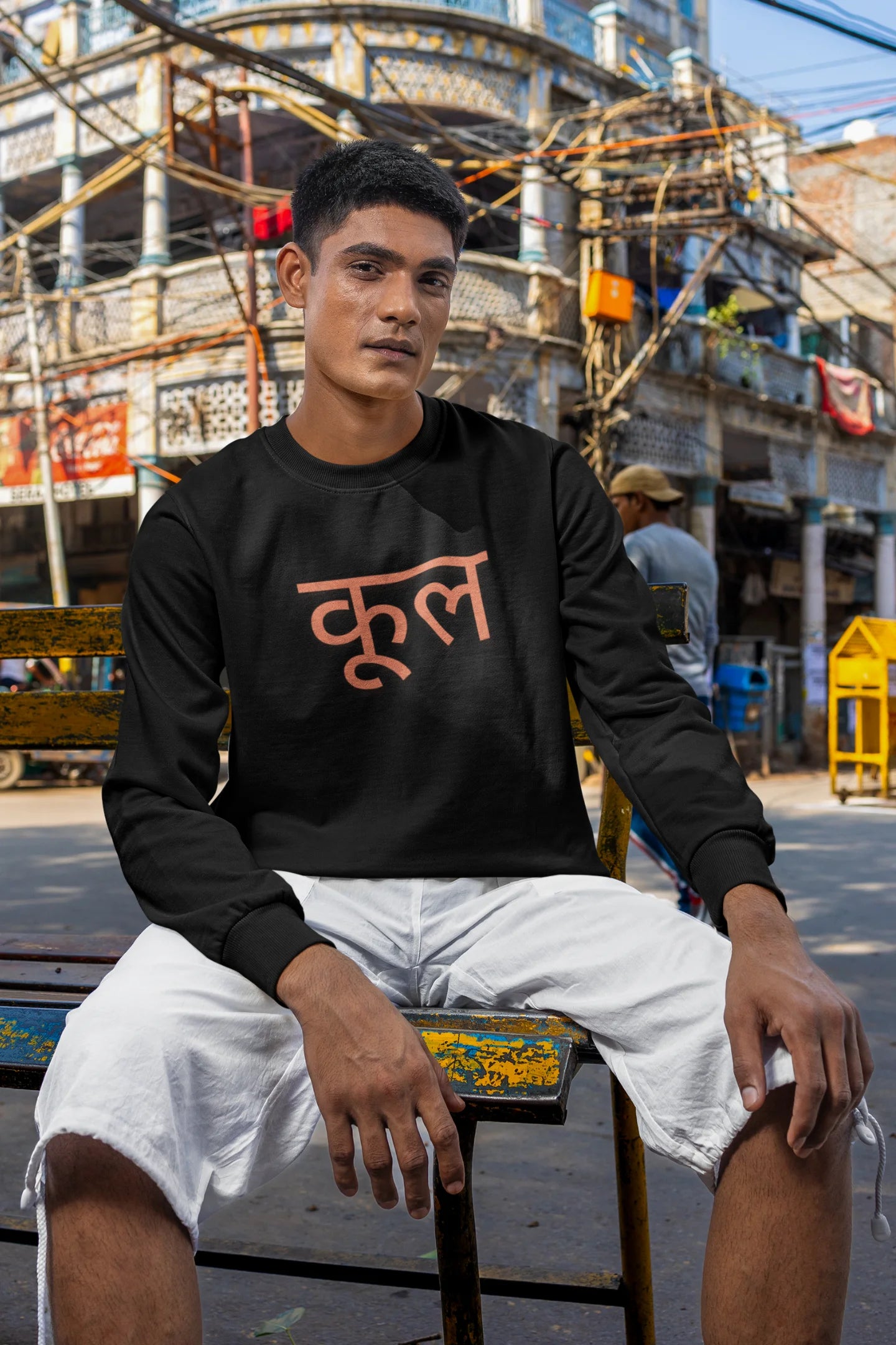 5th front view of a male model wearing a black oversized t-shirt featuring the Hindi word for "cool" with a unique, playful design.