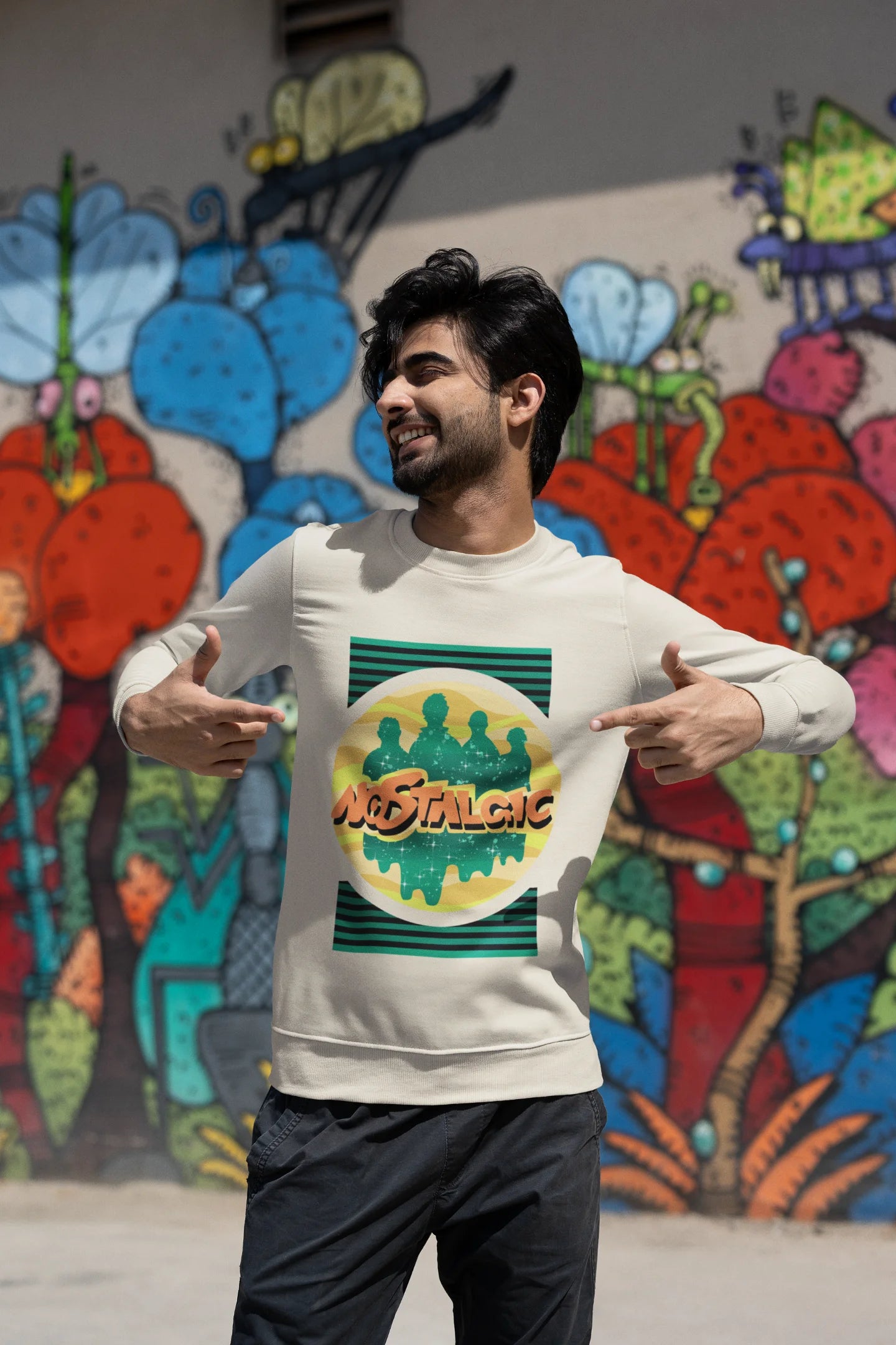 Third view of a male model wearing an oversized cream sweatshirt with a shadow silhouette of the Coldplay band members and the word "Nostalgic" printed on it.