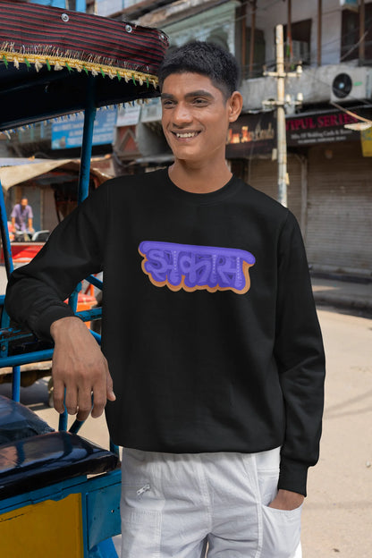 5th front view of a male model wearing an black sweatshirt featuring "Jhakas" in a stylish font.