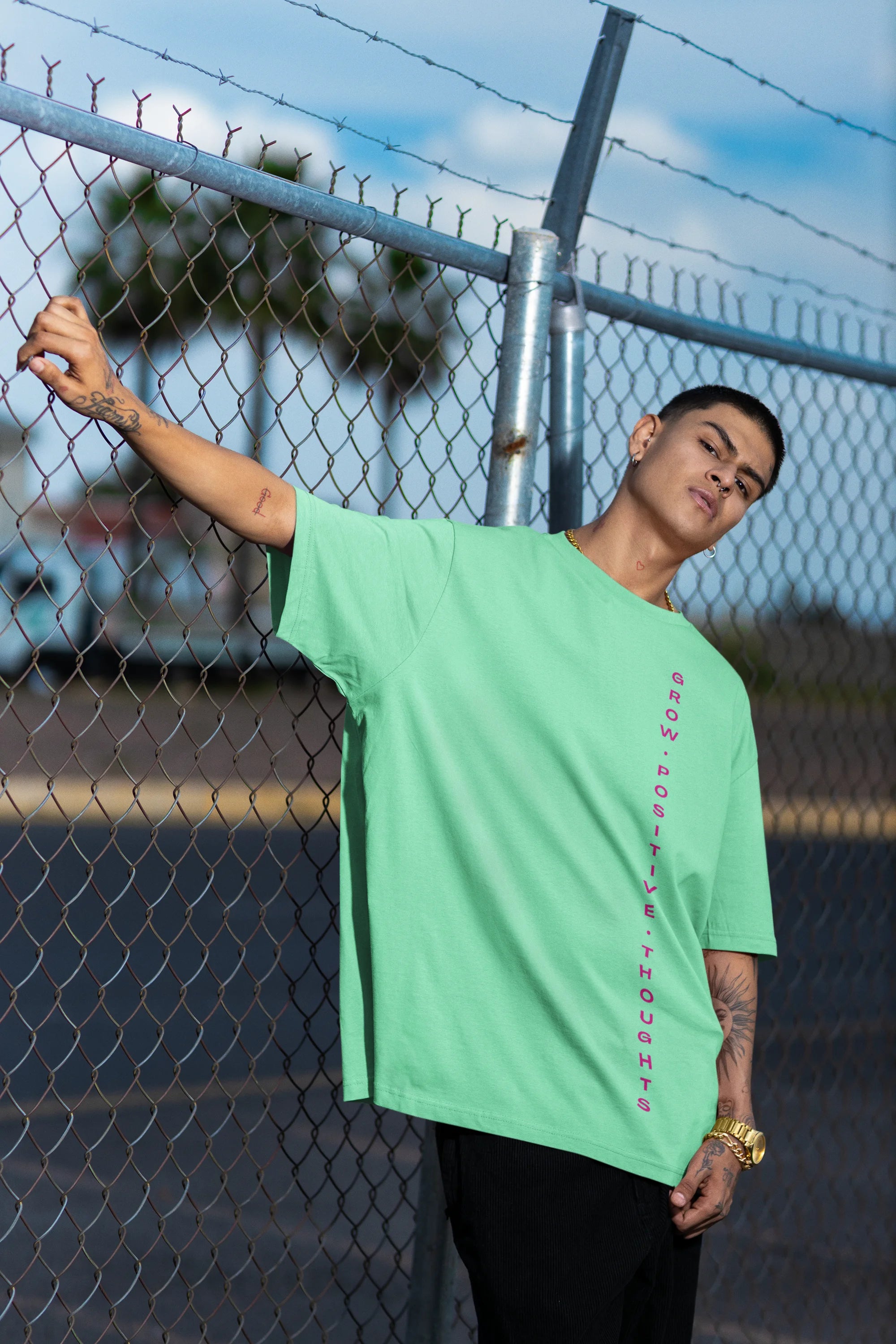 Side view of a male model wearing an mint green oversized t-shirt featuring a thought-provoking design of a man's bust with the text "Think It's Free of Cost." Ideal for those who love funny clothing and the importance of mindful communication.