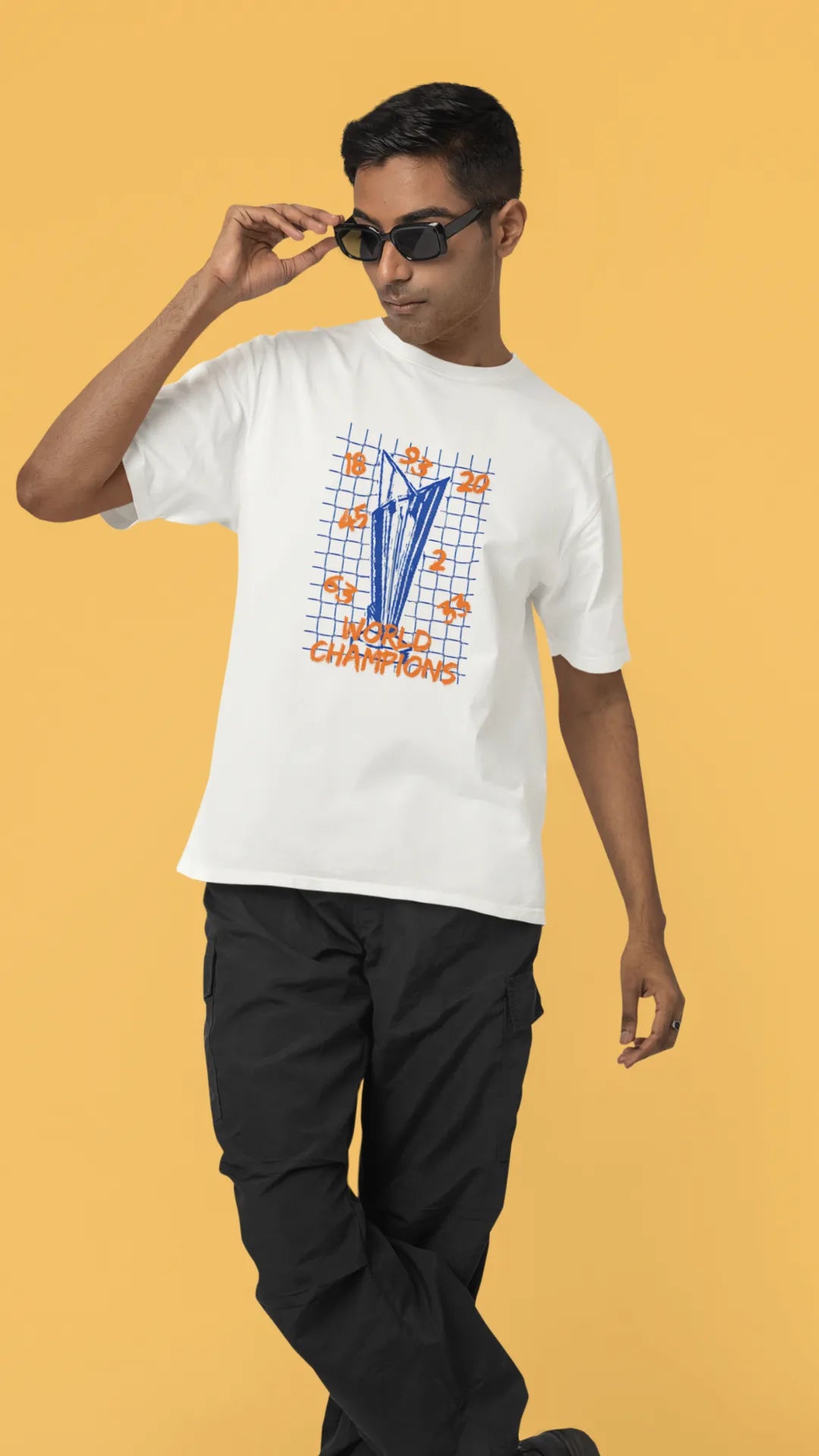 First front image of male model wearing an off-white oversized t-shirt featuring the World Cup 2024 trophy with the text "World Champions" underneath. Ideal for Indian cricket fans celebrating their team's victory.